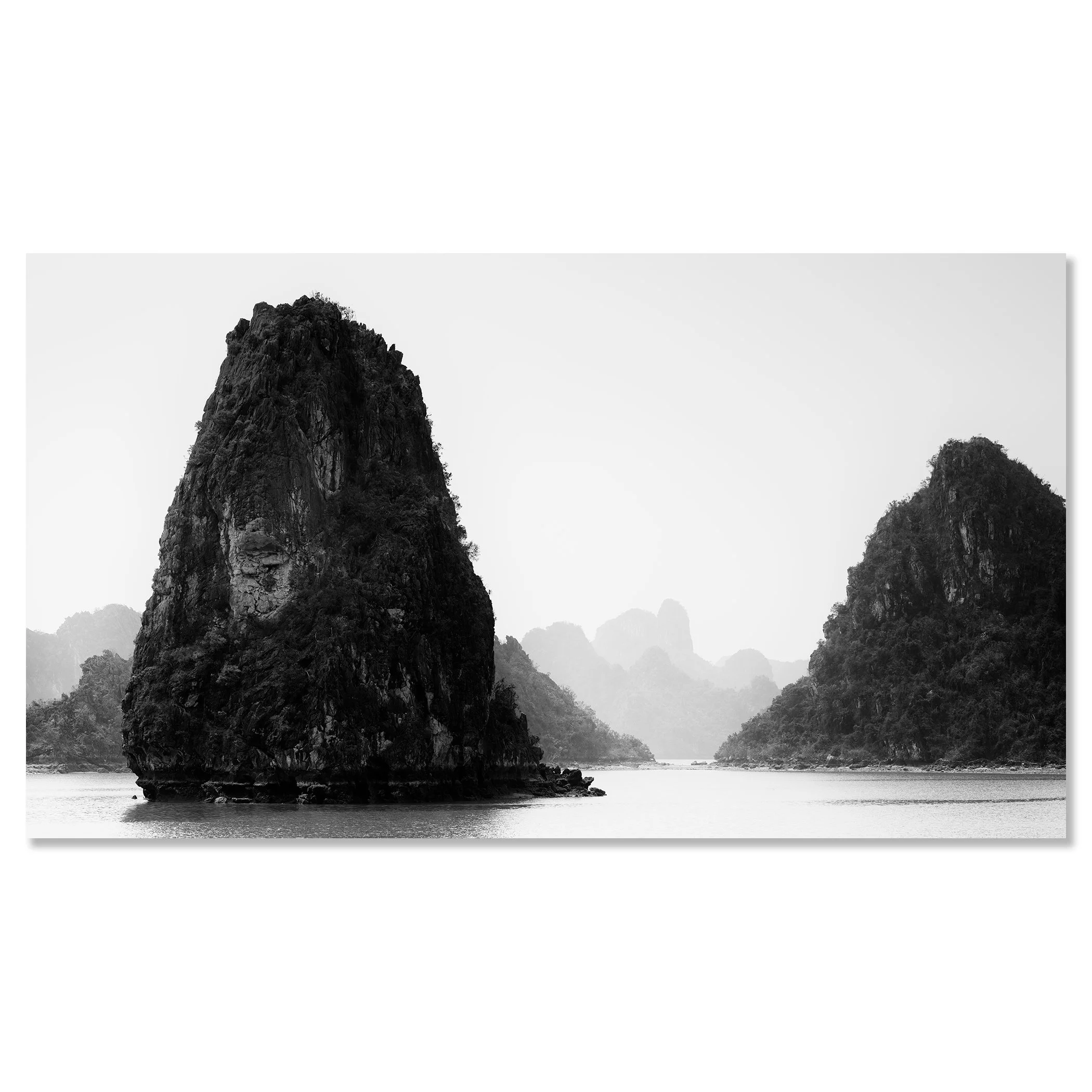 Black-and-white seascape in Vietnam showing limestone karst formations rising from calm water, with misty mountains in the background – dibond frameless