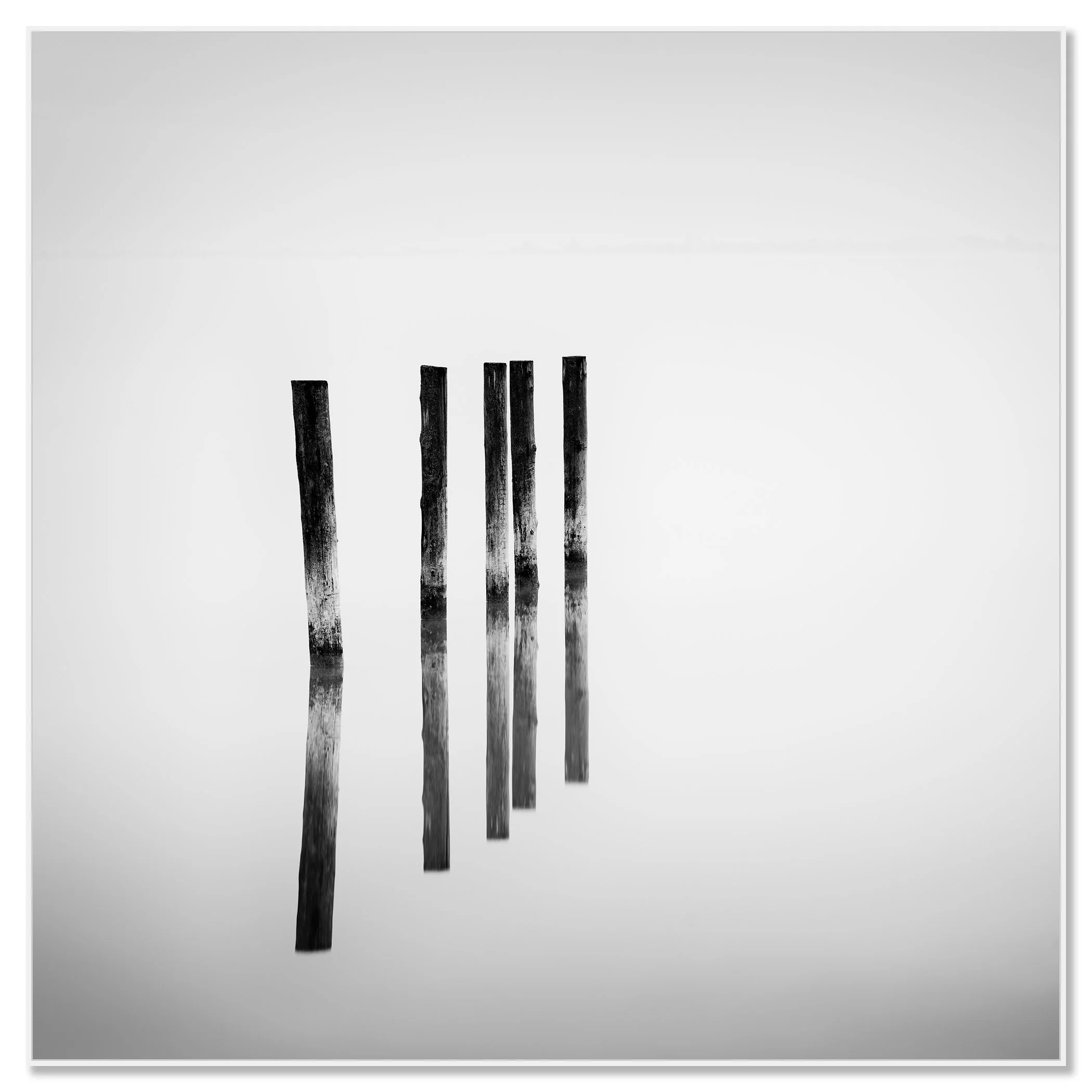 Black and white minimalist image of five vertical wooden posts reflected on a glossy surface – framed ArtBox white