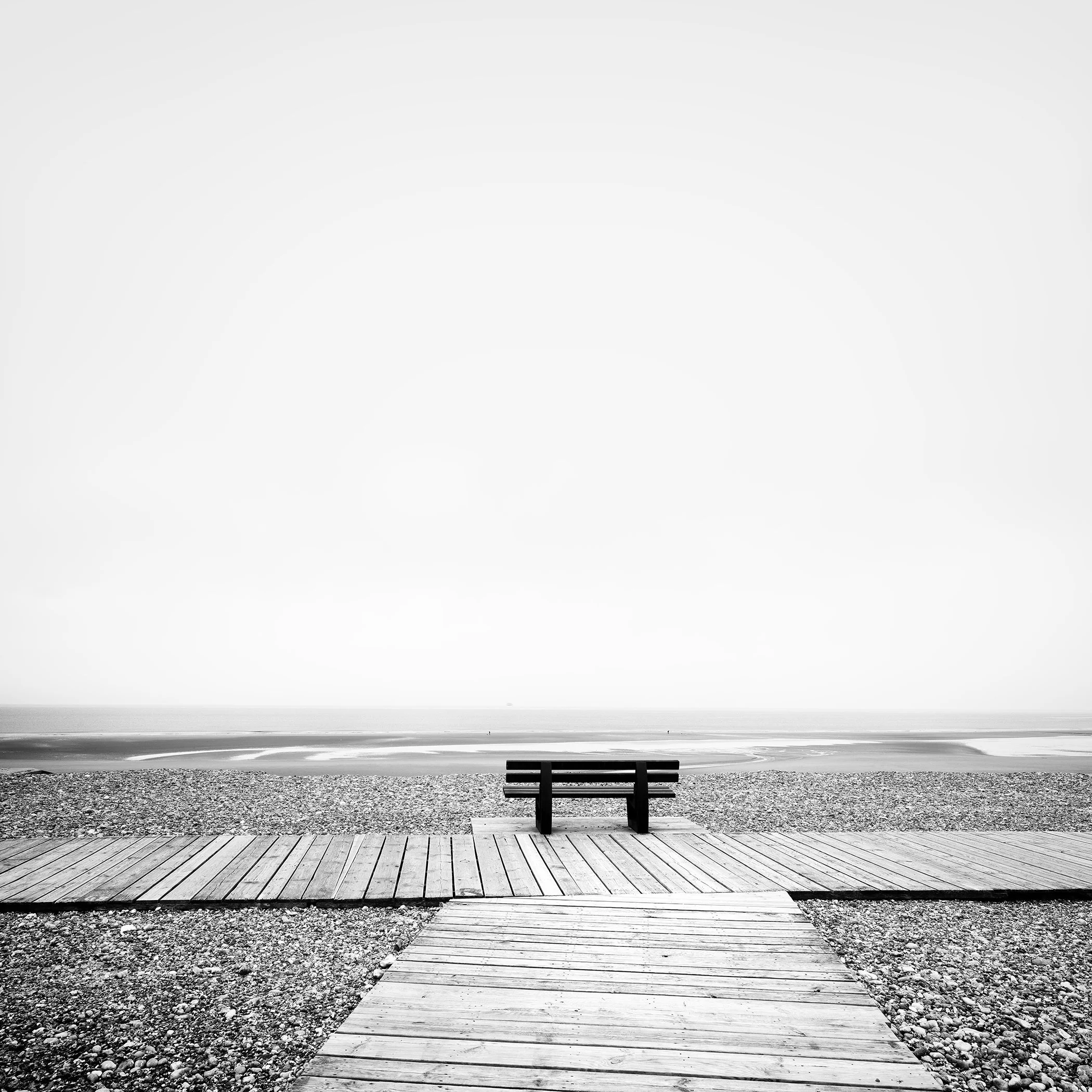 Relaxing Point Study 1 by Gerald Berghammer, minimalist black-and-white fine art photograph of a bench facing the sea in France.
