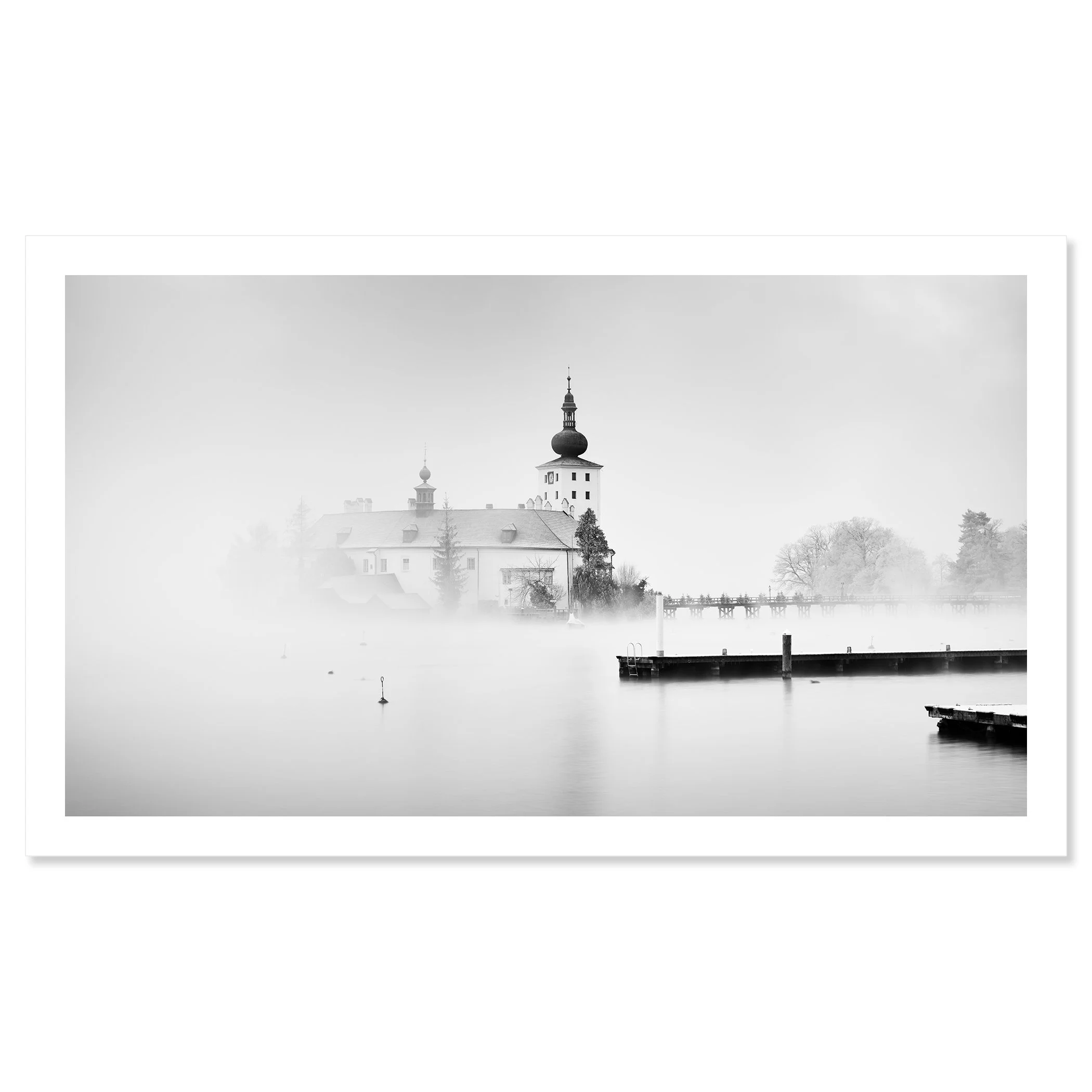 © 2022 Gerald Berghammer - Black and white cityscape photography. Schloss Ort - The historic church surrounded by mist over a lake with docks in the foreground. Fine art print only