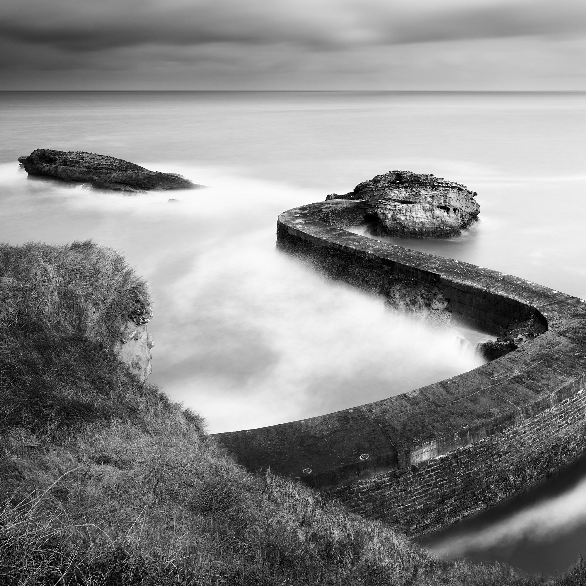 Breakwater Pier Study 1 by Gerald Berghammer, detail of the curved stone breakwater and its textured masonry in a black-and-white fine art photograph.