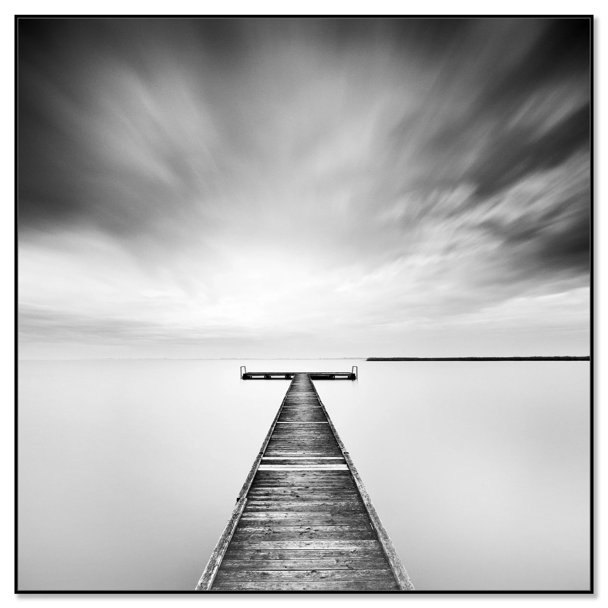 Minimalist black and white landscape photograph of a quiet pier extending into peaceful water – framed ArtBox black