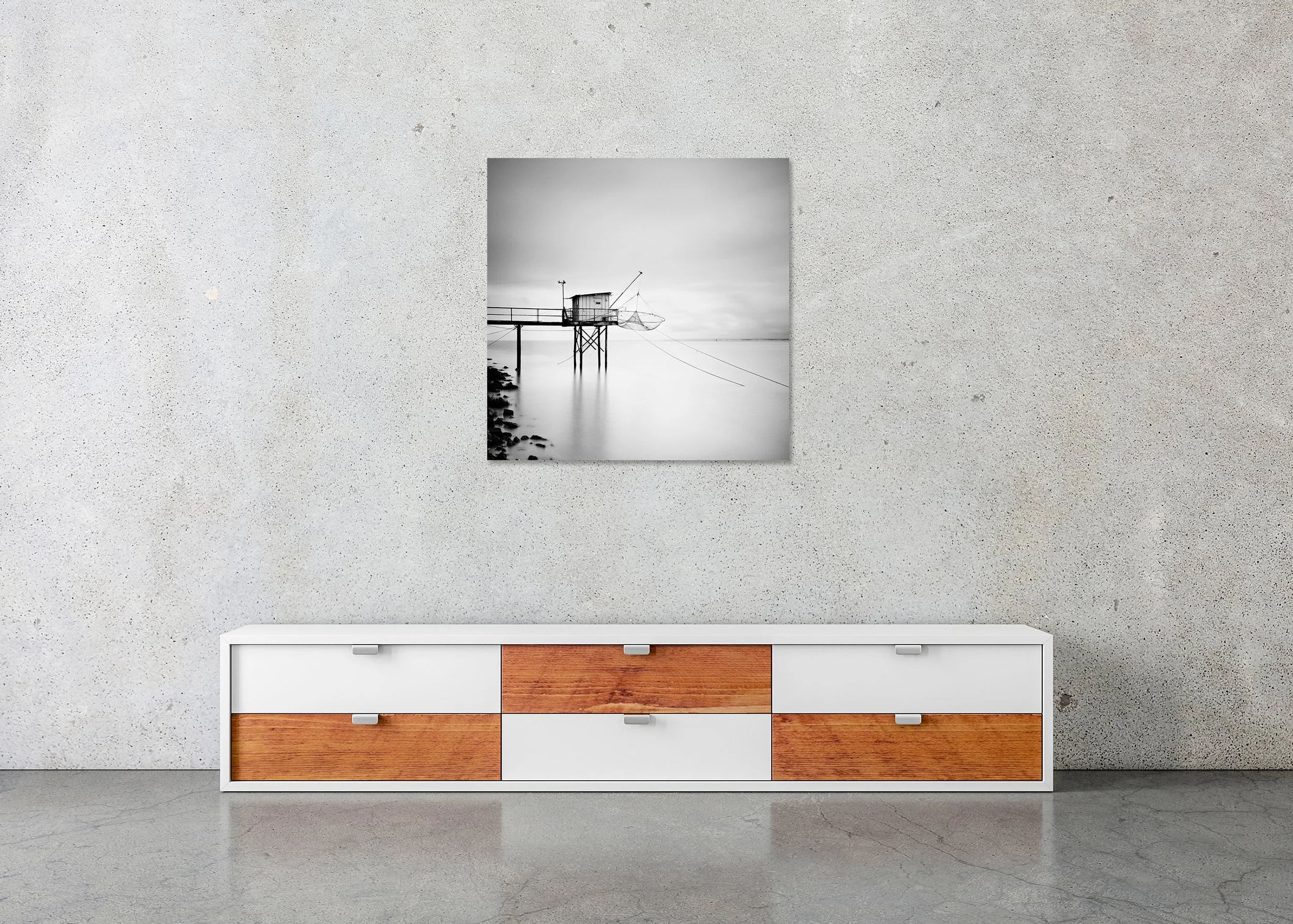 Minimalist black-and-white long-exposure photo of a traditional fishing hut on stilts with nets over a calm sea, ChromaLuxe metal print with a frameless finish.