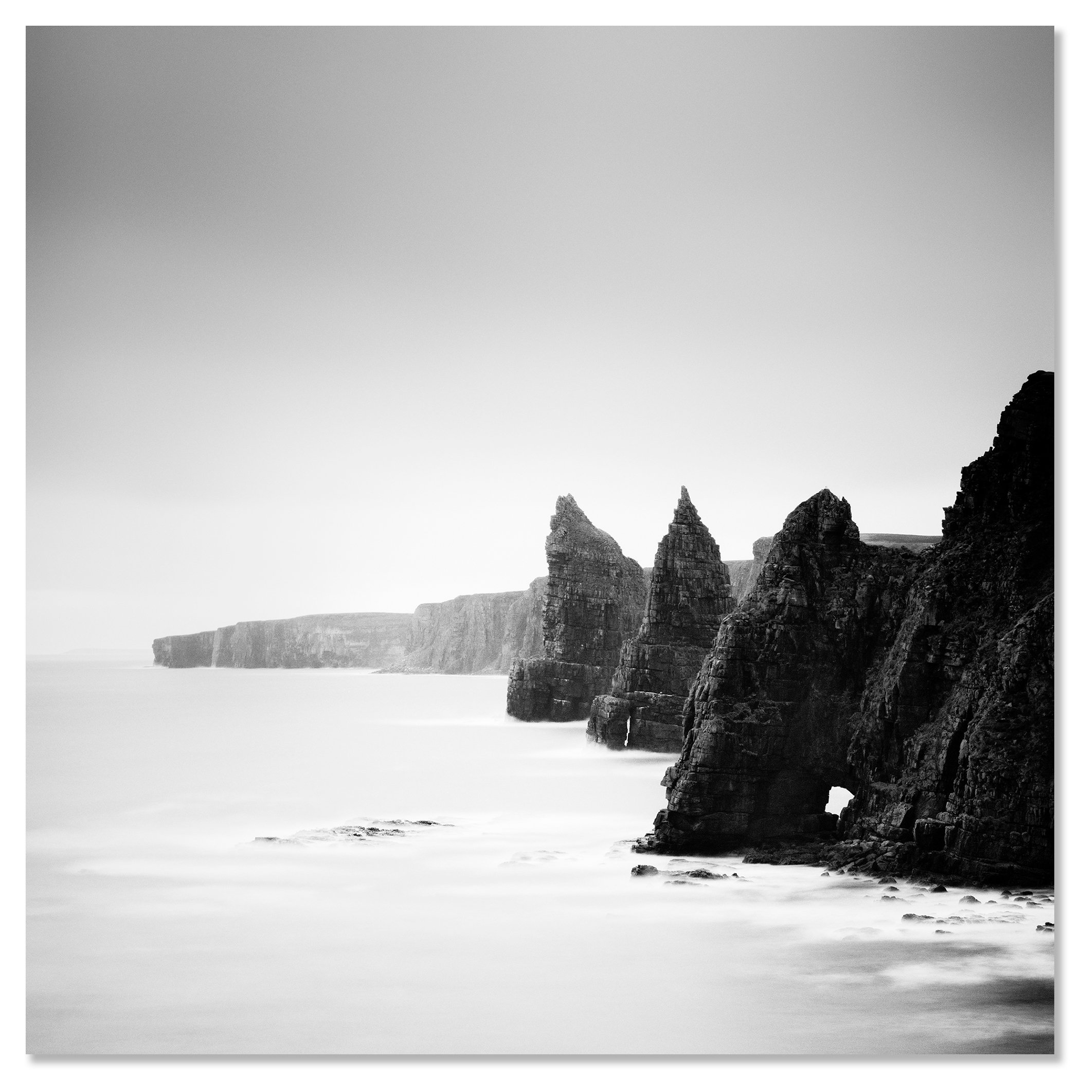 Black and white view of the Duncansby Stacks on the rocky coast of Scotland with calm sea – dibond frameless
