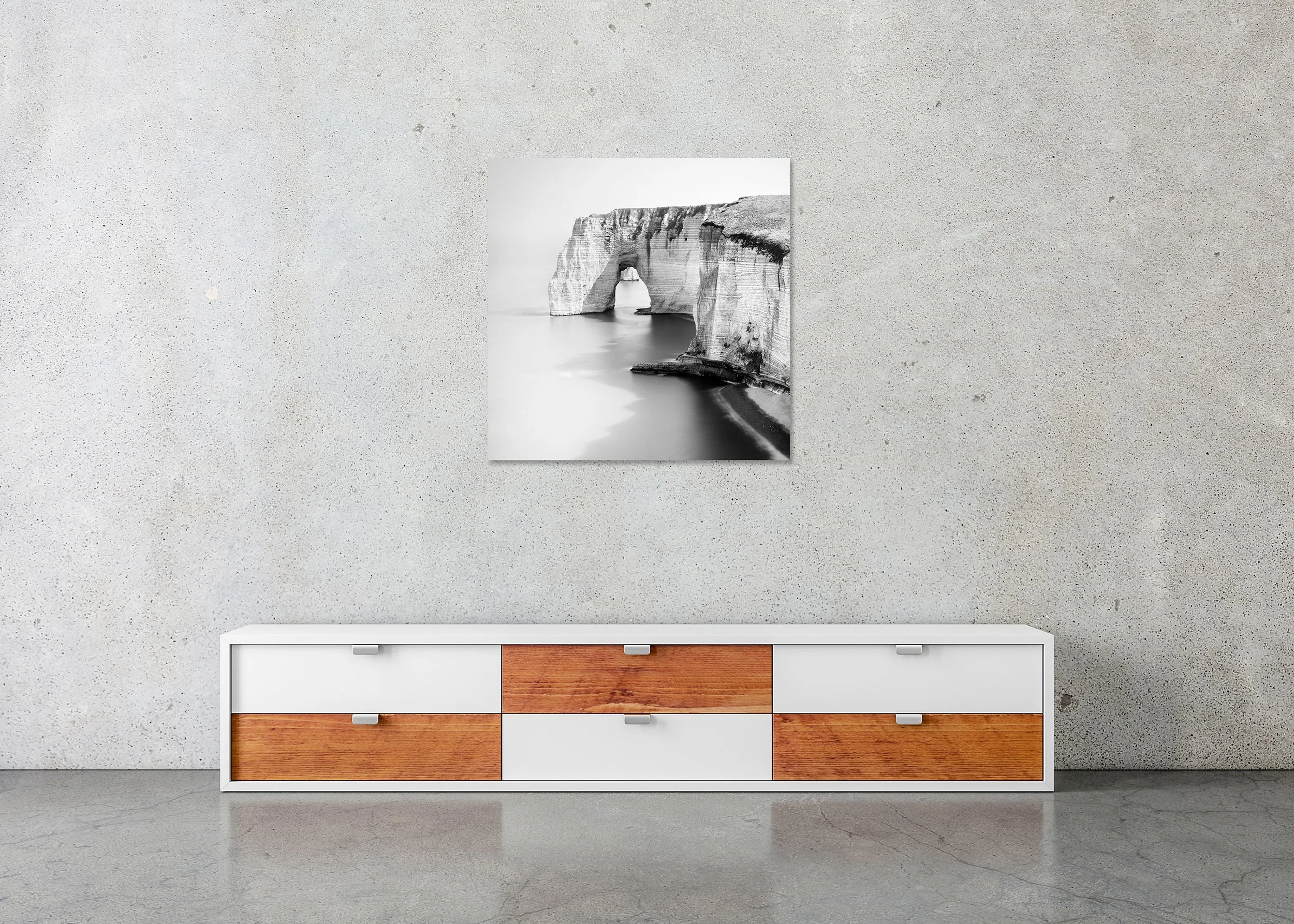 Black and white photo print of a rugged coastline with a natural rock arch above the water, mounted to Dibond, frameless