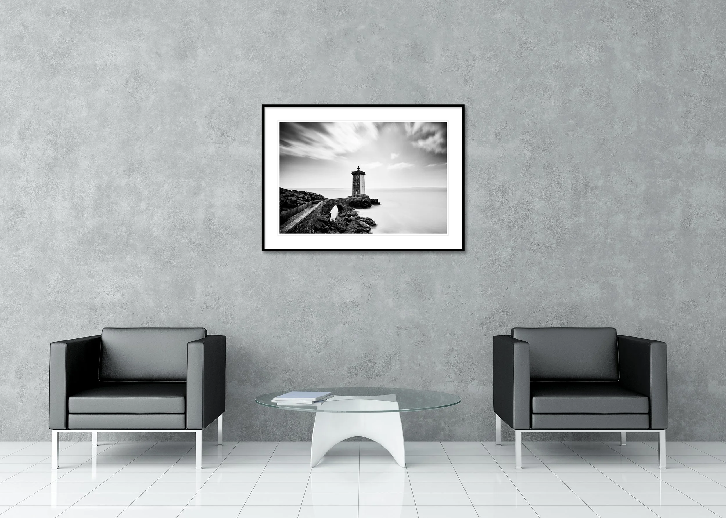Black and white long-exposure photo of a coastal lighthouse on rocky cliffs, linked by a stone bridge, as an archival pigment print in a classic frame with a mount.
