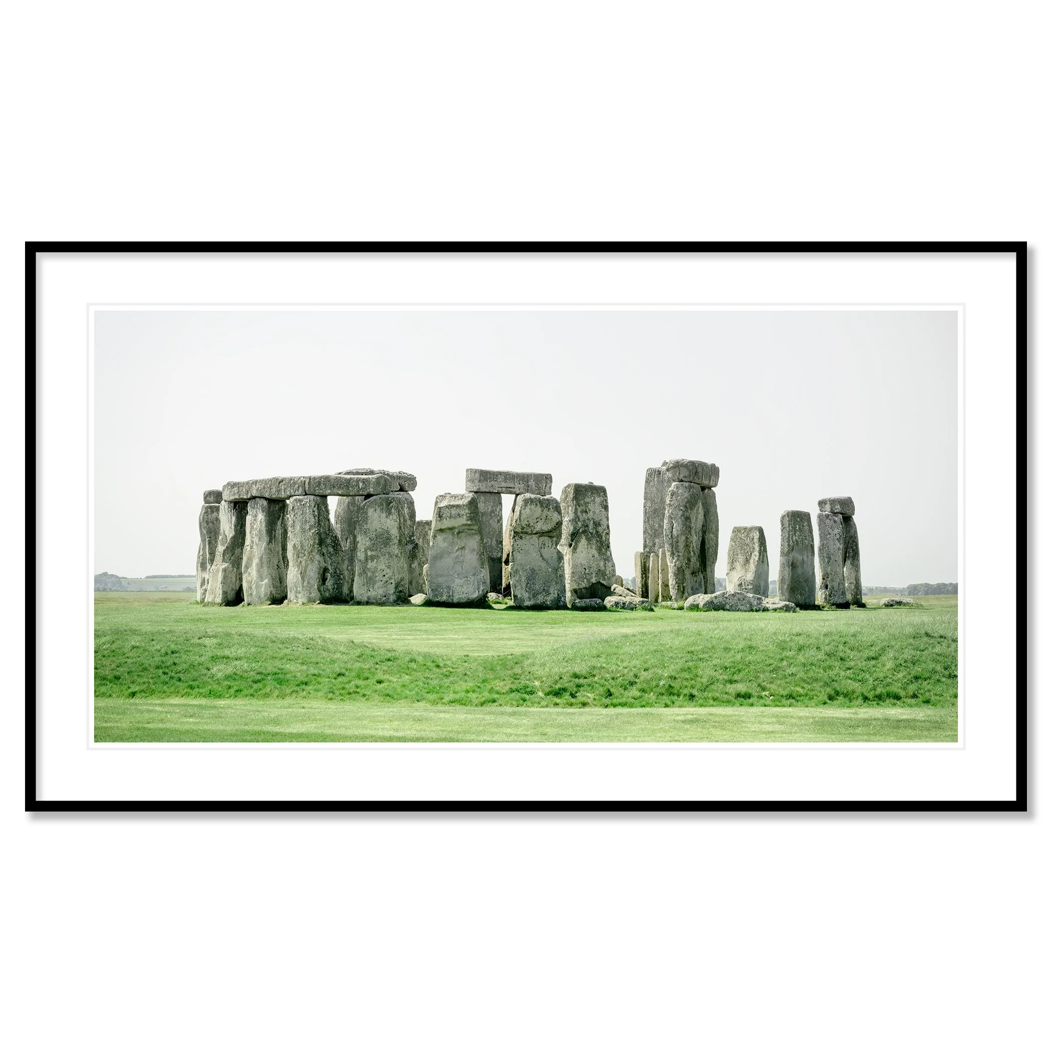 Gerald Berghammer - Color landscape panorama photography. Historic Stonehenge monument with large standing stones on a grassy field under a gray sky. Classic framed black