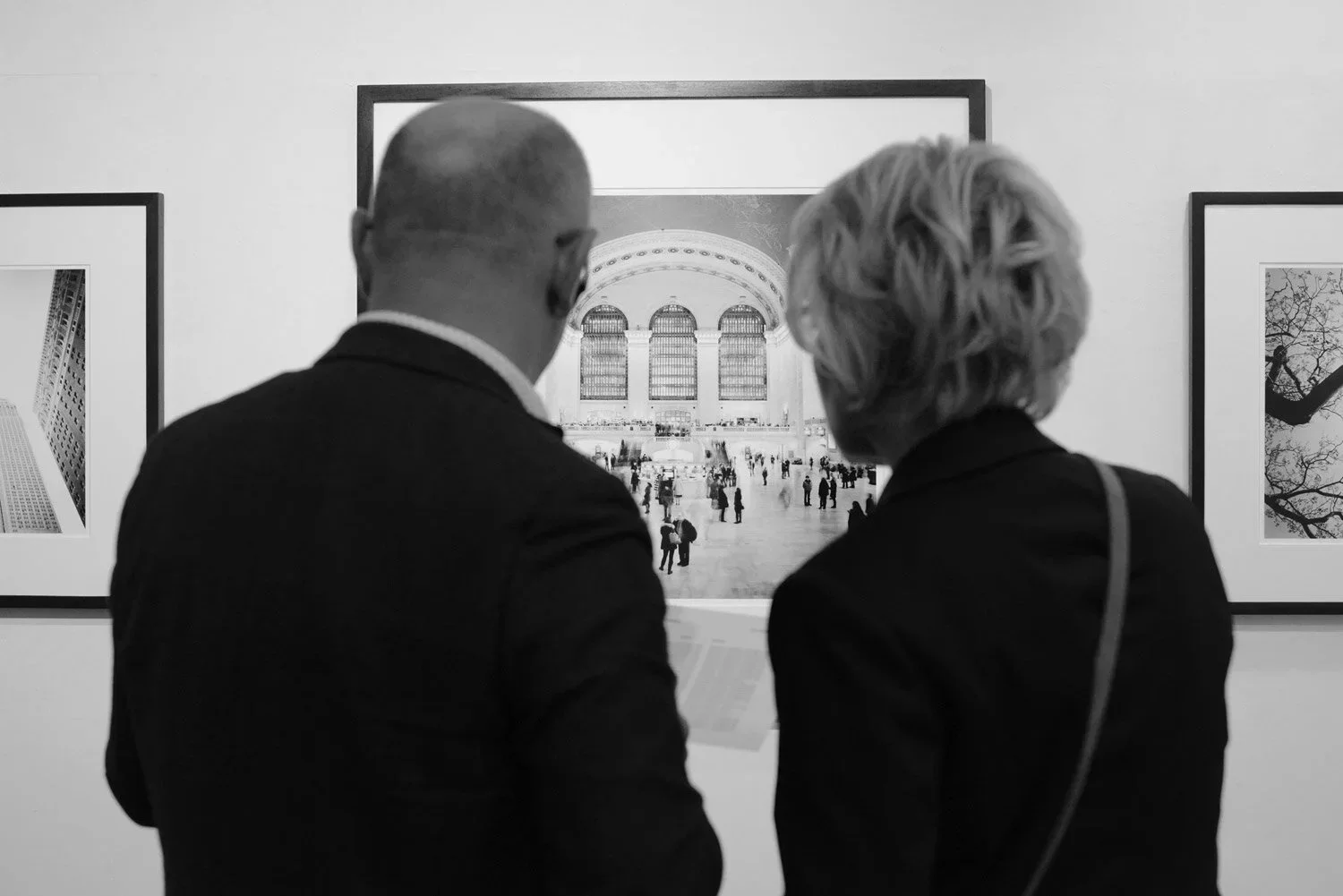 Two visitors viewing a black-and-white railway station interior photograph by Gerald Berghammer at Galerie STP during ESSENTIAL LIGHT 2018.