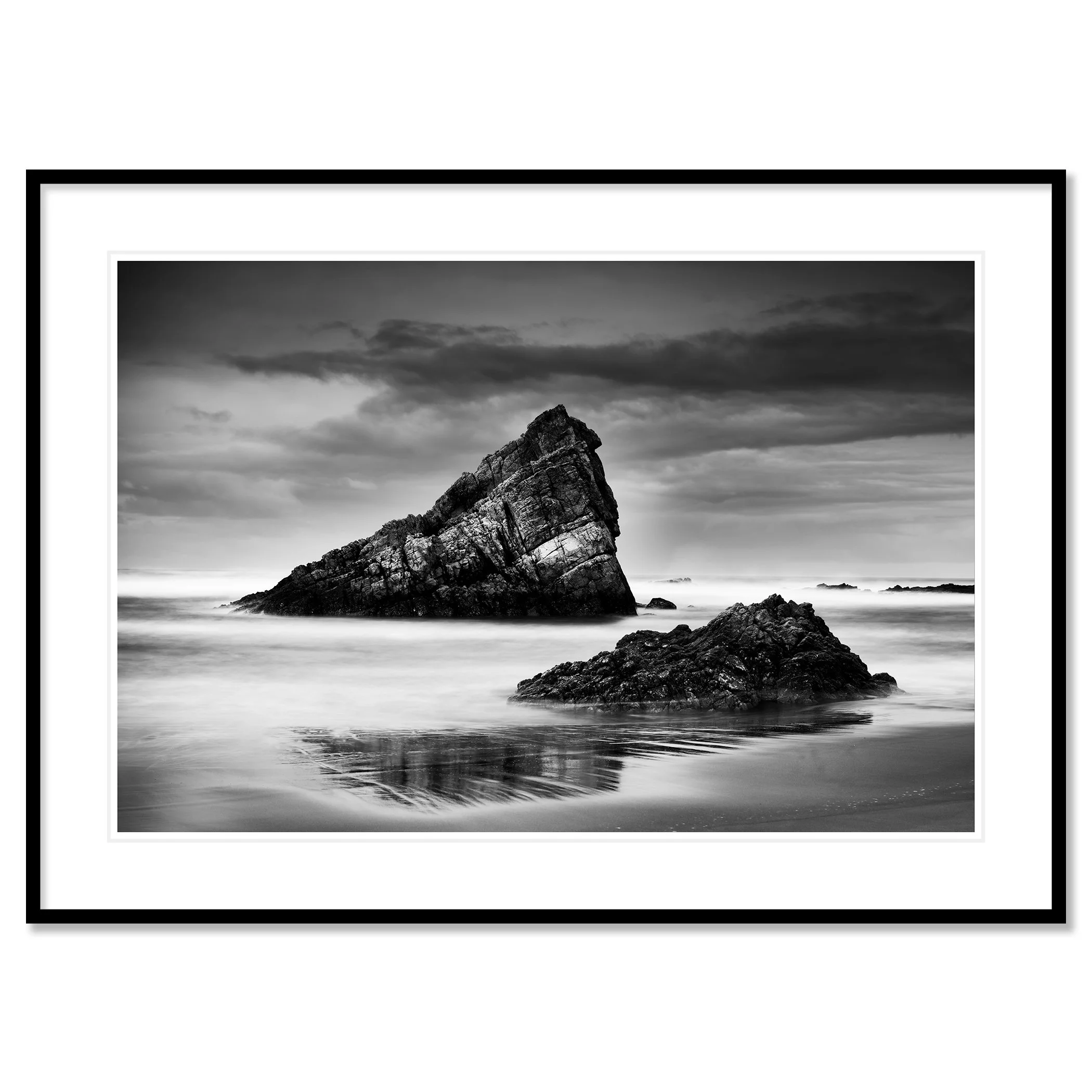 © 2023 Gerald Berghammer. Black-and-white photograph of jagged sea rocks emerging from calm water under a cloudy sky. Classic framed black
