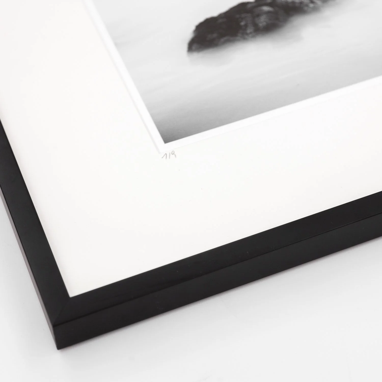 Detail of the bevelled white archival mount and handmade black wooden frame surrounding Sea Stack Study 2 by Gerald Berghammer.