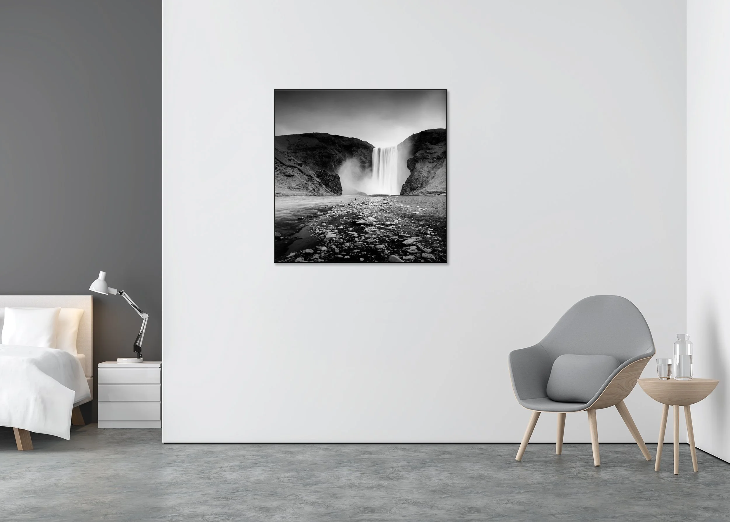 Black and white photograph of Skogafoss waterfall in Iceland cascading between dark volcanic cliffs with a rocky riverbed in the foreground, presented as a ChromaLuxe aluminium ArtBox metal print.