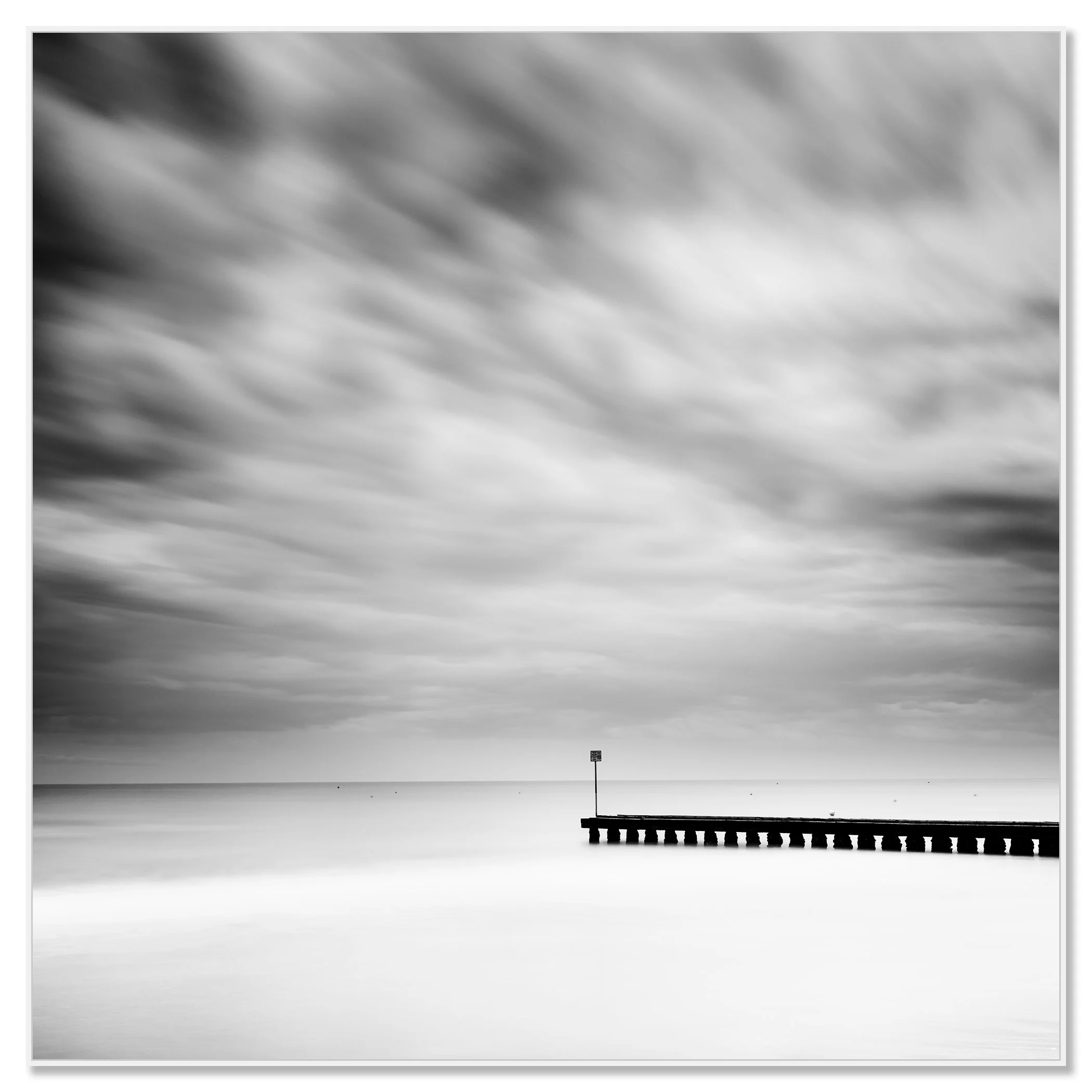 Wooden Pier in the Sea Study 1 – black-and-white long-exposure seascape from Italy mounted on aluminium Dibond in a white ArtBox frame by Gerald Berghammer.