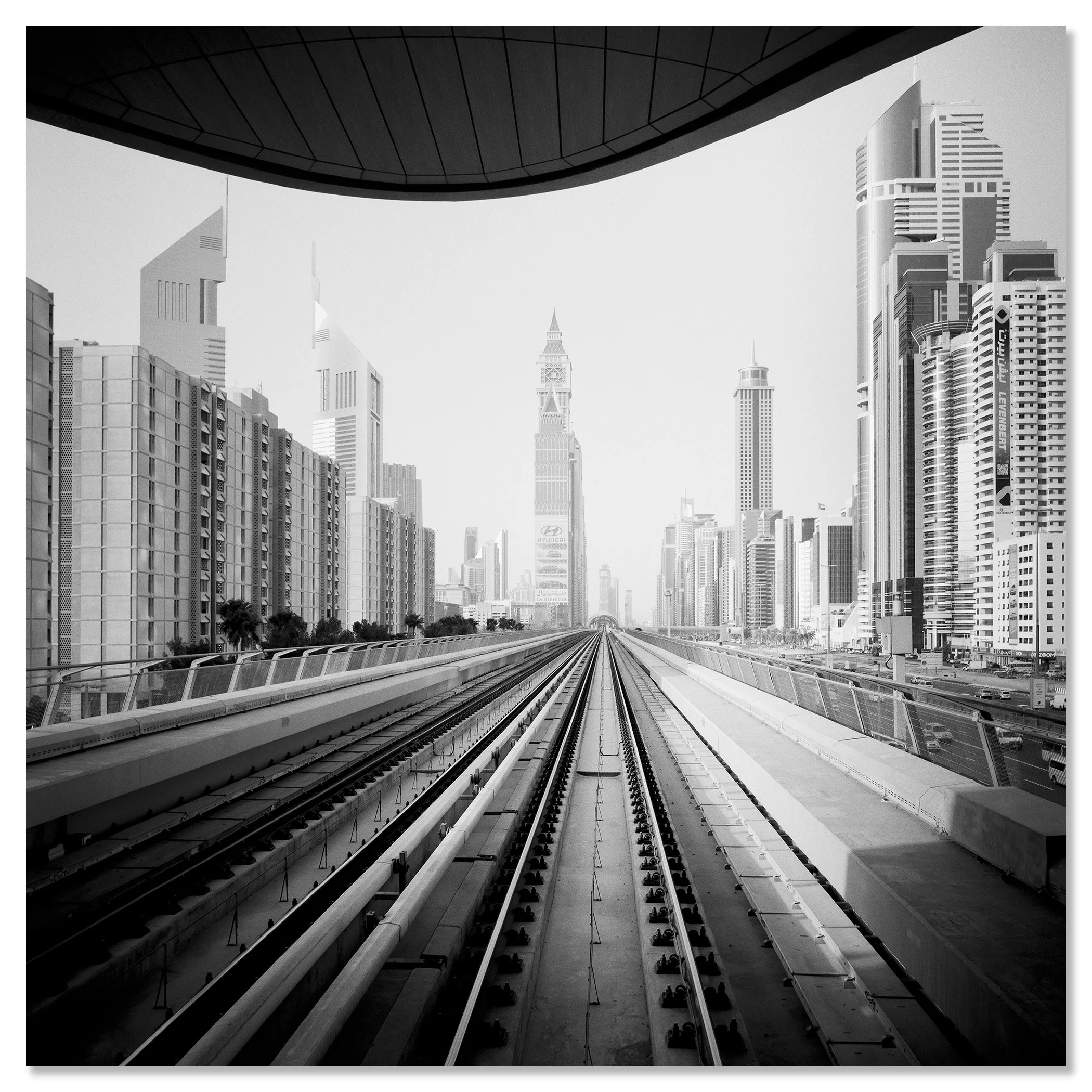 Surreal World displayed as a frameless black-and-white aluminium Dibond print of Dubai’s Metro tracks and skyline by Gerald Berghammer.