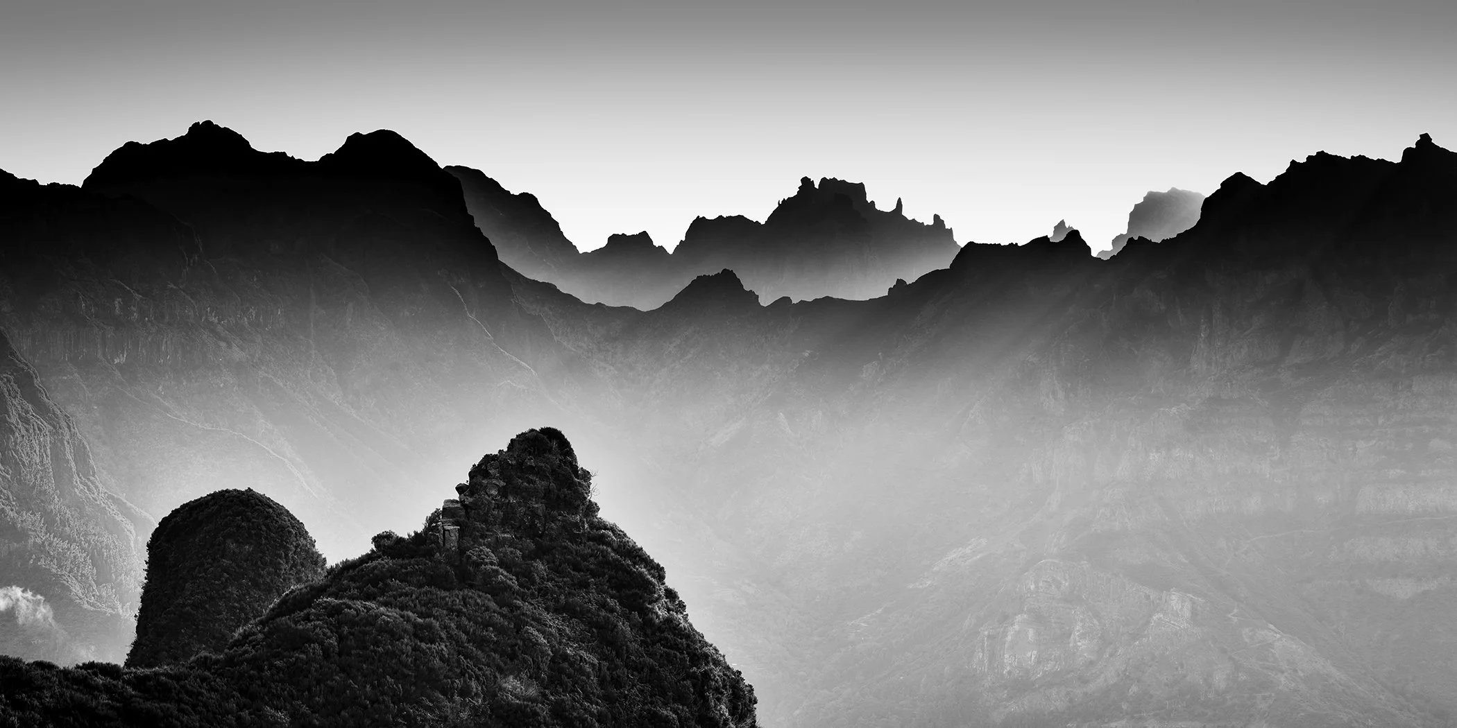 Panoramic black-and-white photograph of misty mountain ridges in Madeira, Portugal, by Gerald Berghammer.