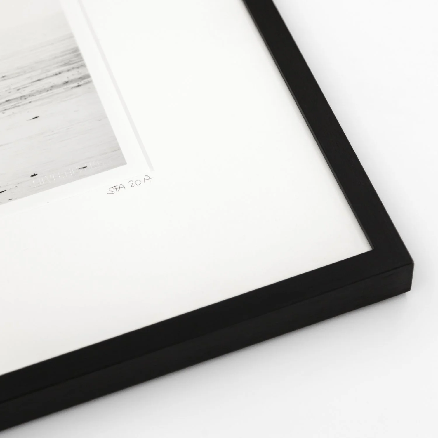 Close-up of the black wooden frame, white archival mount and photograph of Harness Racing – France by Gerald Berghammer.