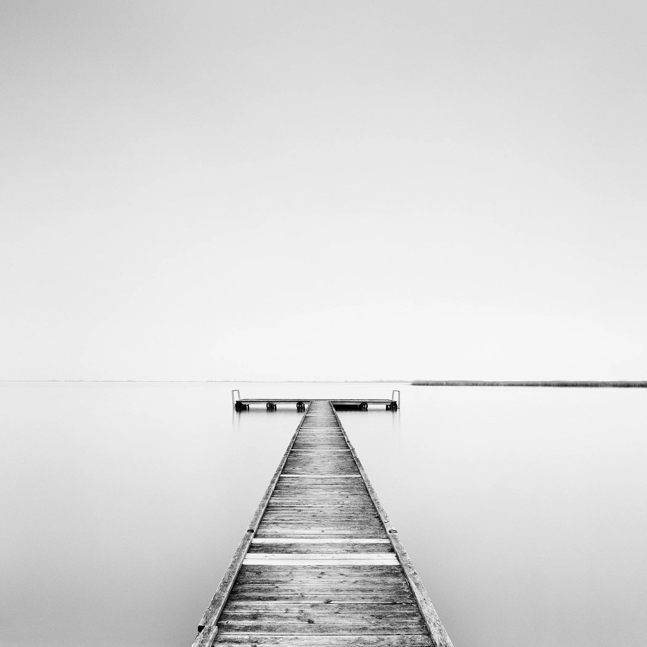 Pier Study 1, minimalist black-and-white fine art photograph of a wooden pier on calm Lake Neusiedl, Austria, by Gerald Berghammer.