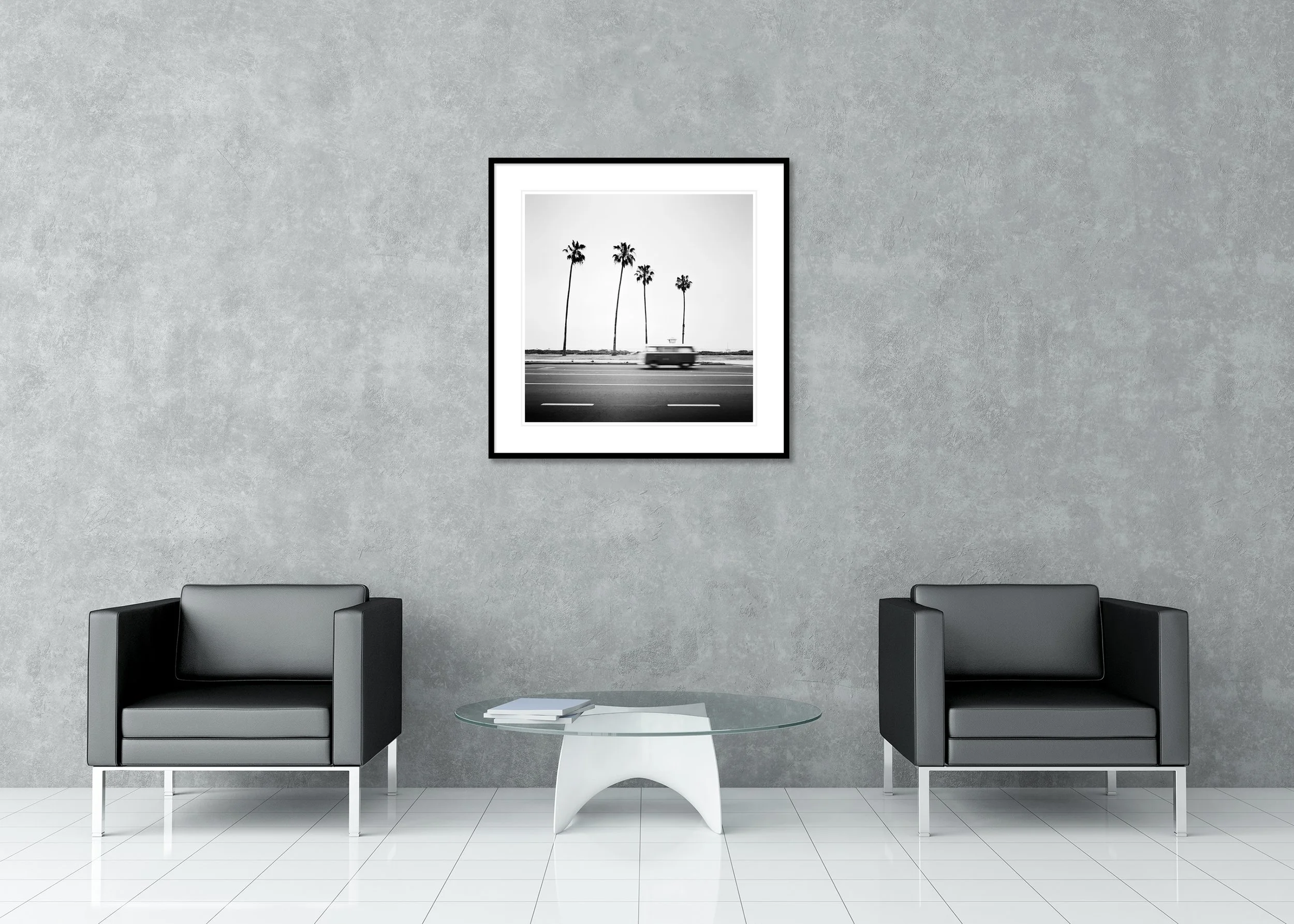 Black-and-white photo of a blurred vintage VW bus on a coastal road in Santa Barbara with tall palm trees, archival pigment print in a classic frame with mount.