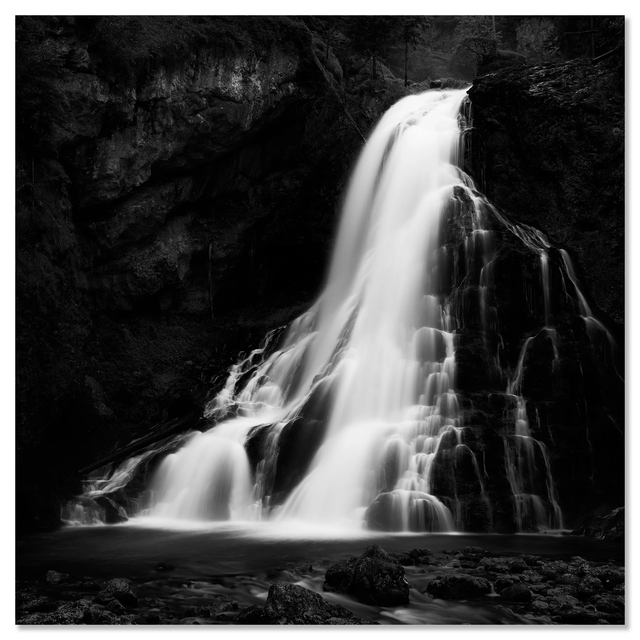Black-and-white photograph of a waterfall cascading down a rocky cliff into a pool below – dibond frameless