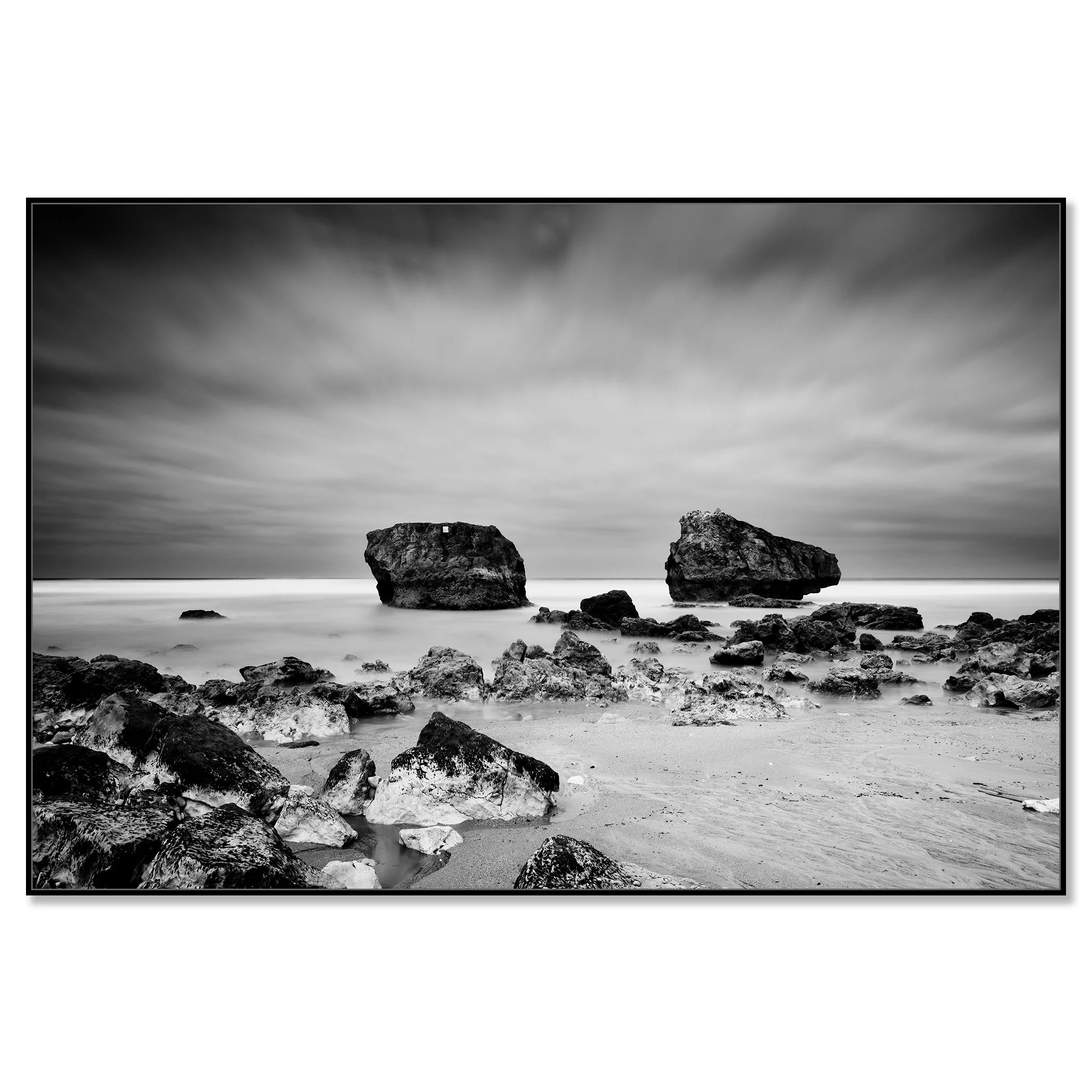 Black and white landscape photo of a rocky beach with two sea stacks, cloudy sky and smooth ocean water – framed ArtBox black