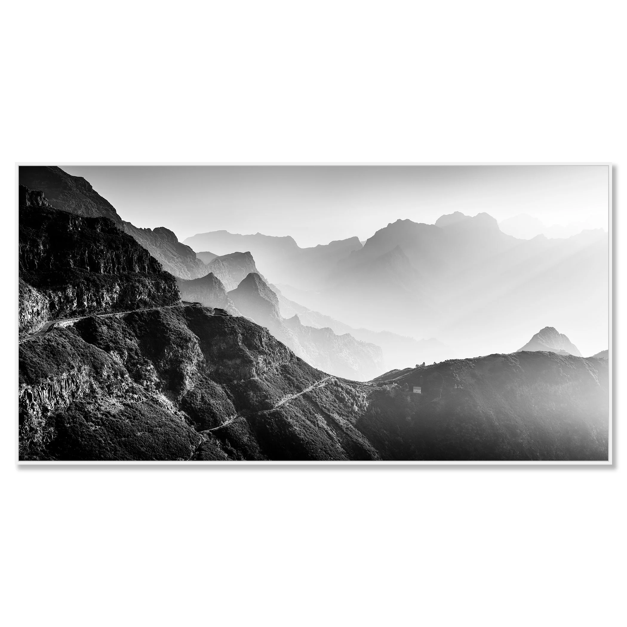 Black-and-white mountain landscape with layered peaks, a winding road and soft atmospheric haze – framed ArtBox white