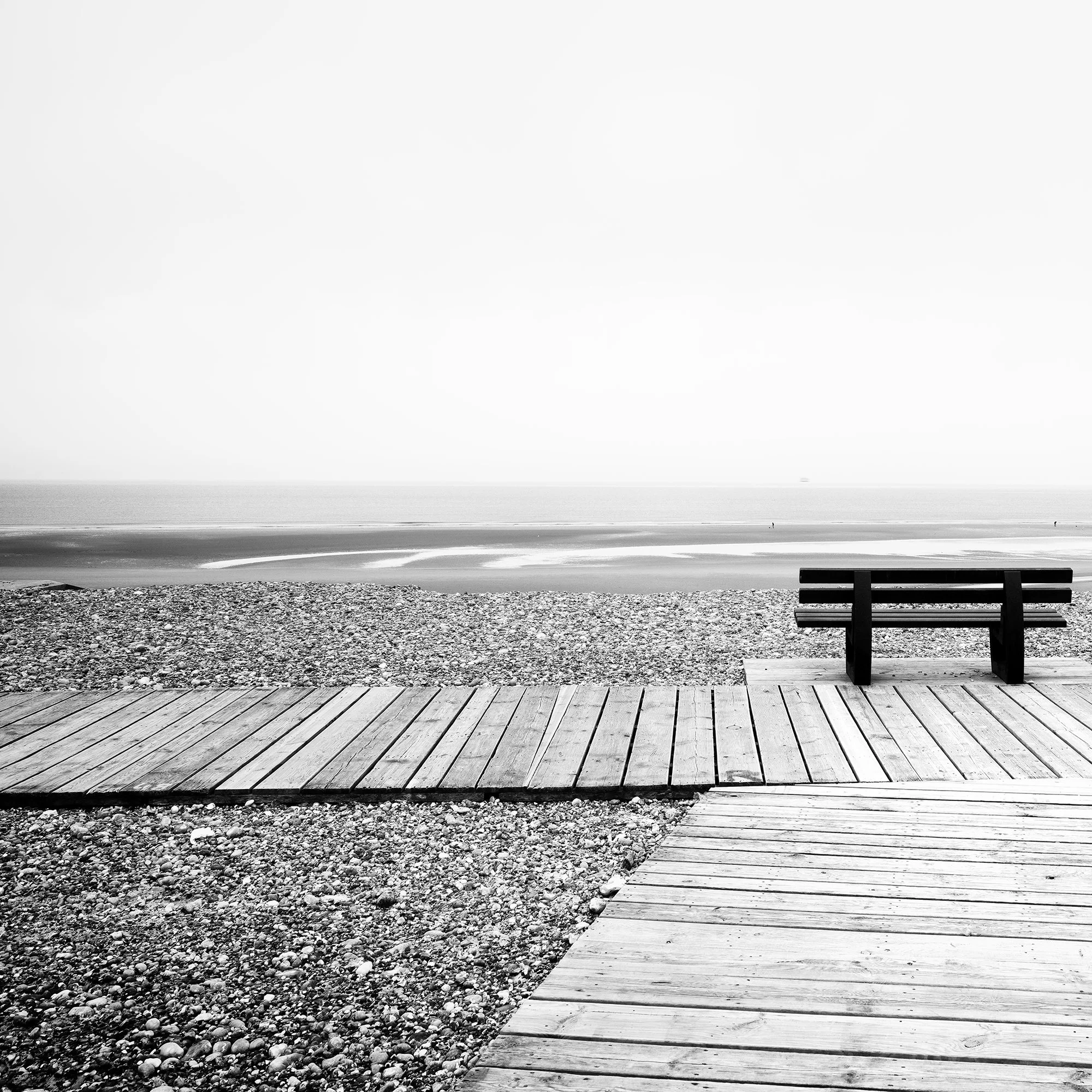Detail of Relaxing Point Study 1 by Gerald Berghammer, showing the wooden boardwalk, bench and French coastline in black-and-white.