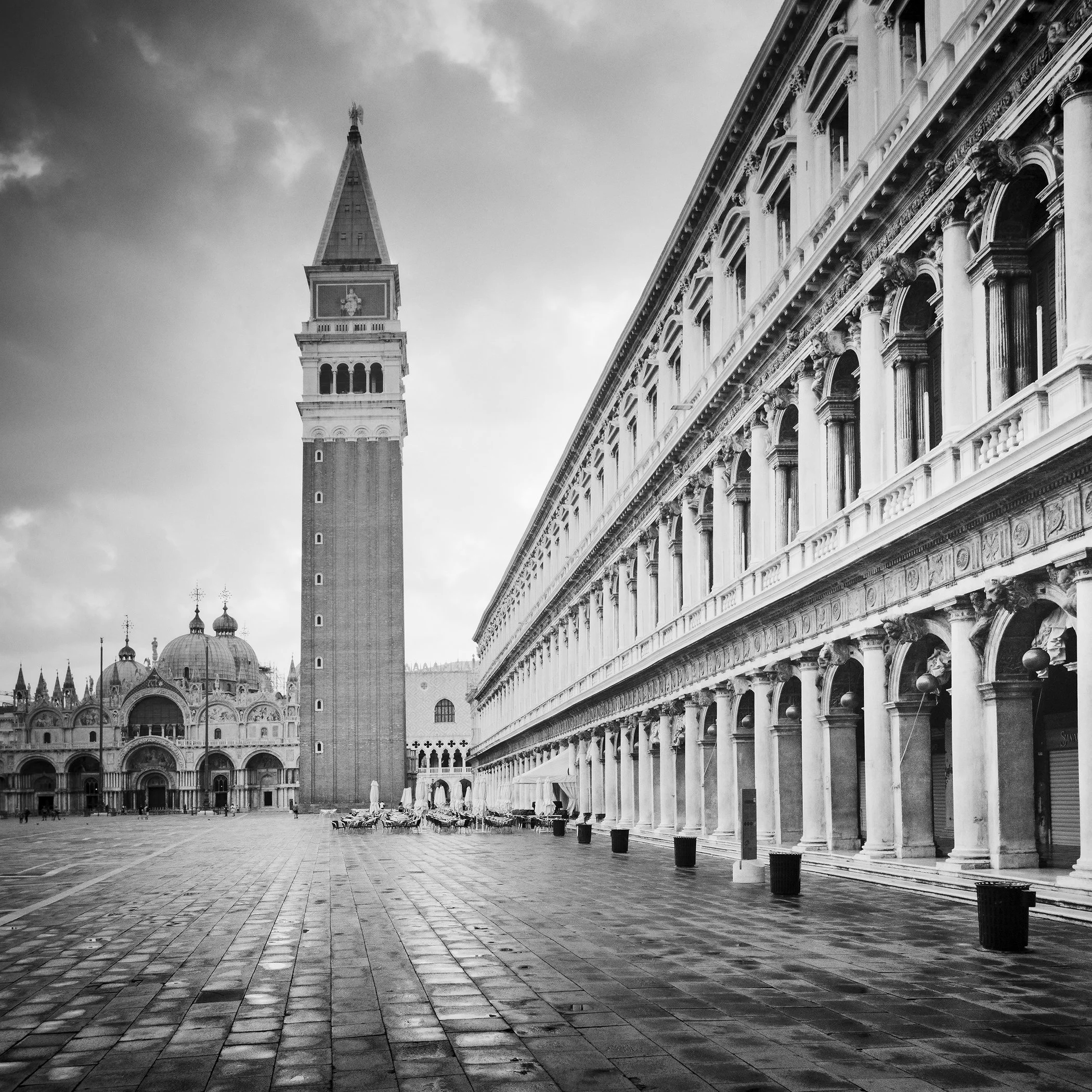 Gerald Berghammer - B&W Cityscape Photography. St. Mark's Square in Venice, showing the Campanile bell tower, St. Mark's Basilica and historic buildings.