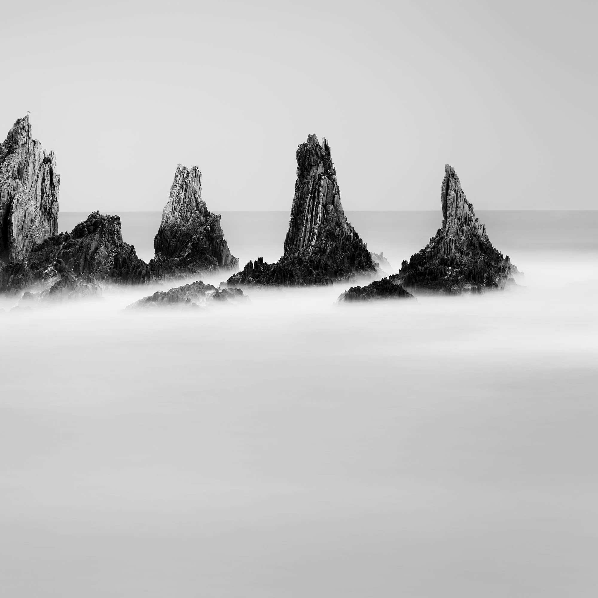 Rocky Peaks Study 1 by Gerald Berghammer, cropped view of jagged Atlantic sea stacks and smooth long-exposure water in Spain.