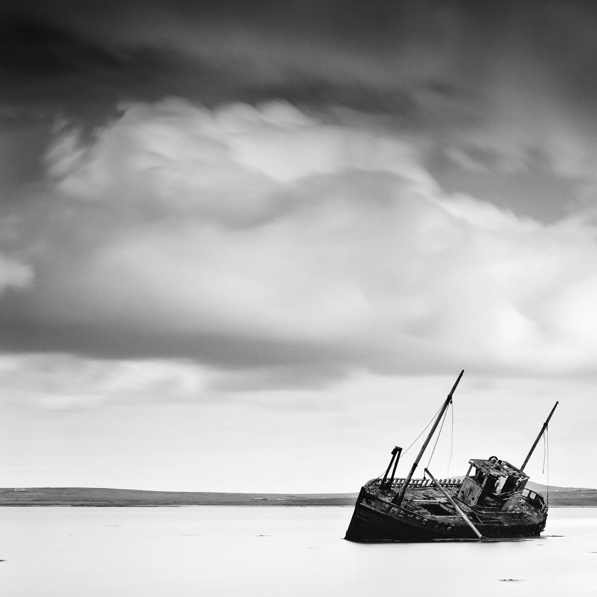 © 2014 Gerald Berghammer - Black and white minimalist seascape photography. An abandoned boat stuck in shallow water with cloudy sky overhead. Print detail 1