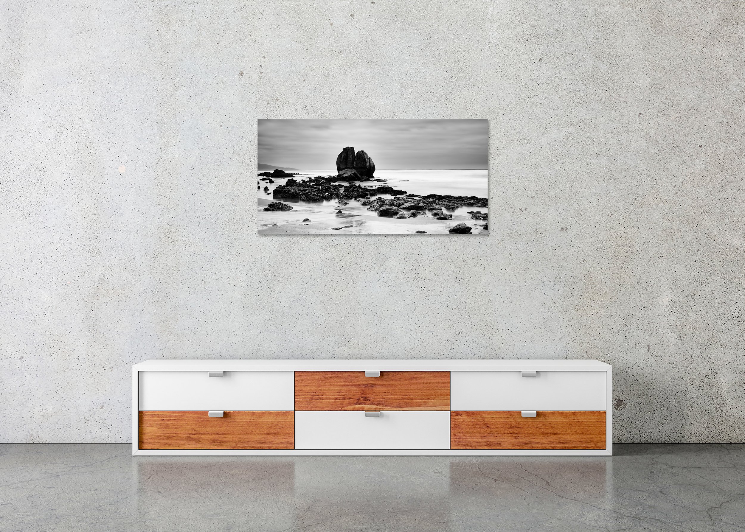 Black and white long-exposure photo print of a rocky beach and sea under a cloudy sky, mounted to Dibond, frameless