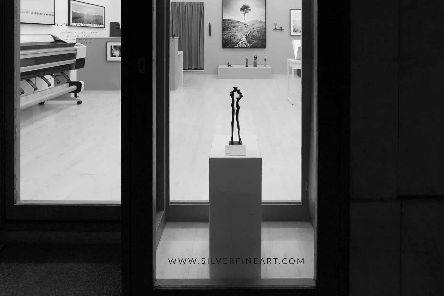 SILVERFINEART Gallery window display with a figurative sculpture and black-and-white photography by Gerald Berghammer.