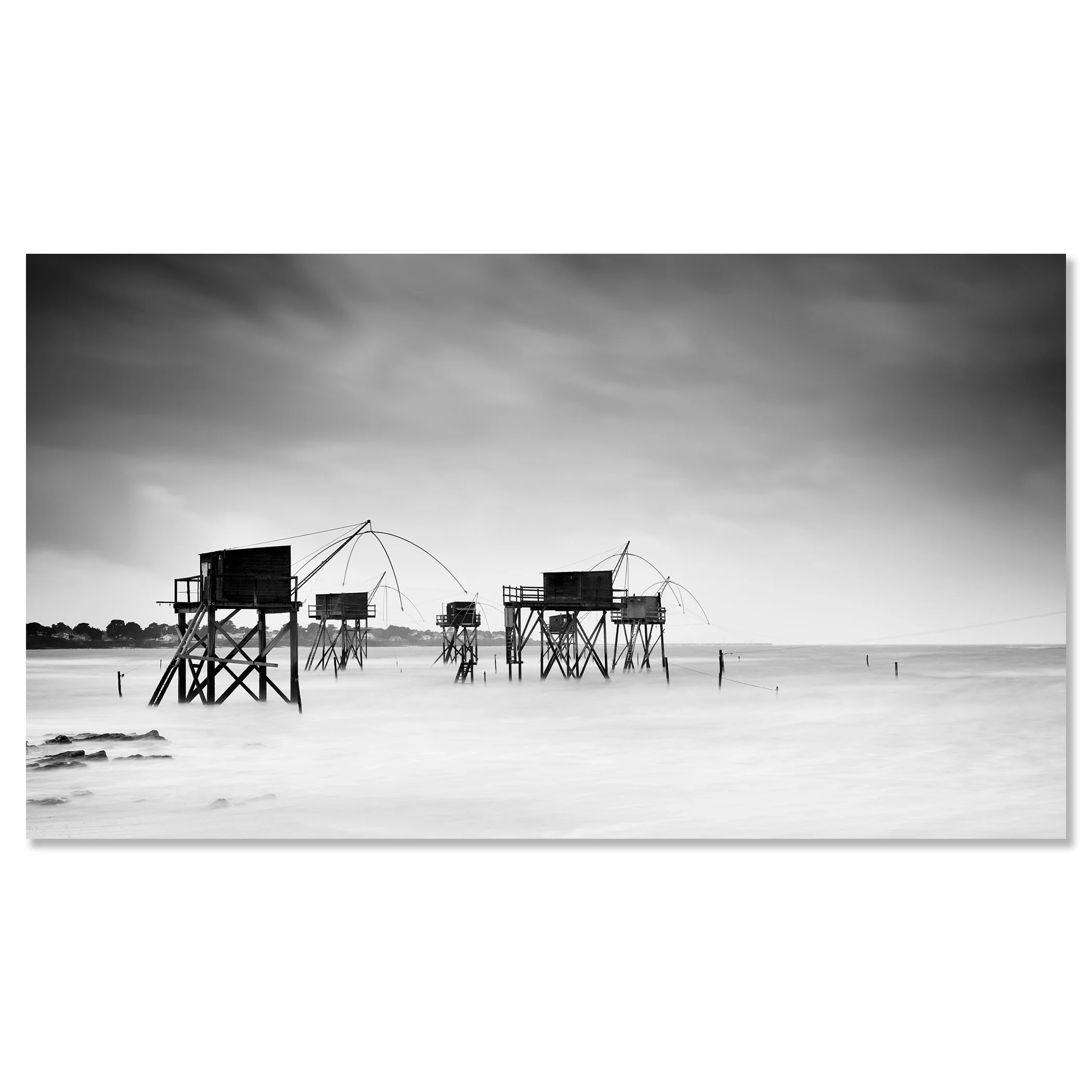 Gerald Berghammer - Black and white seascape photography. Fishing huts on stilts over water, with fishing nets hanging from the structures, under a cloudy sky. Chromaluxe frameless
