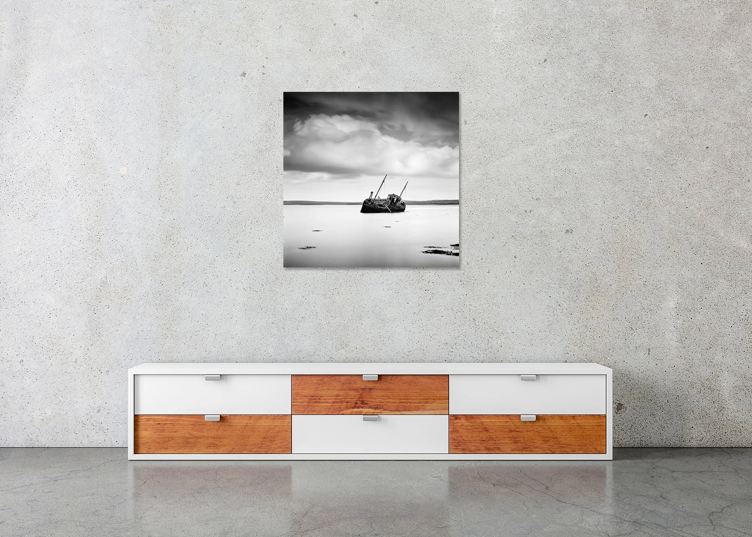 Black-and-white photo print of an abandoned boat on calm water in Ireland beneath dramatic clouds, mounted to Dibond, frameless