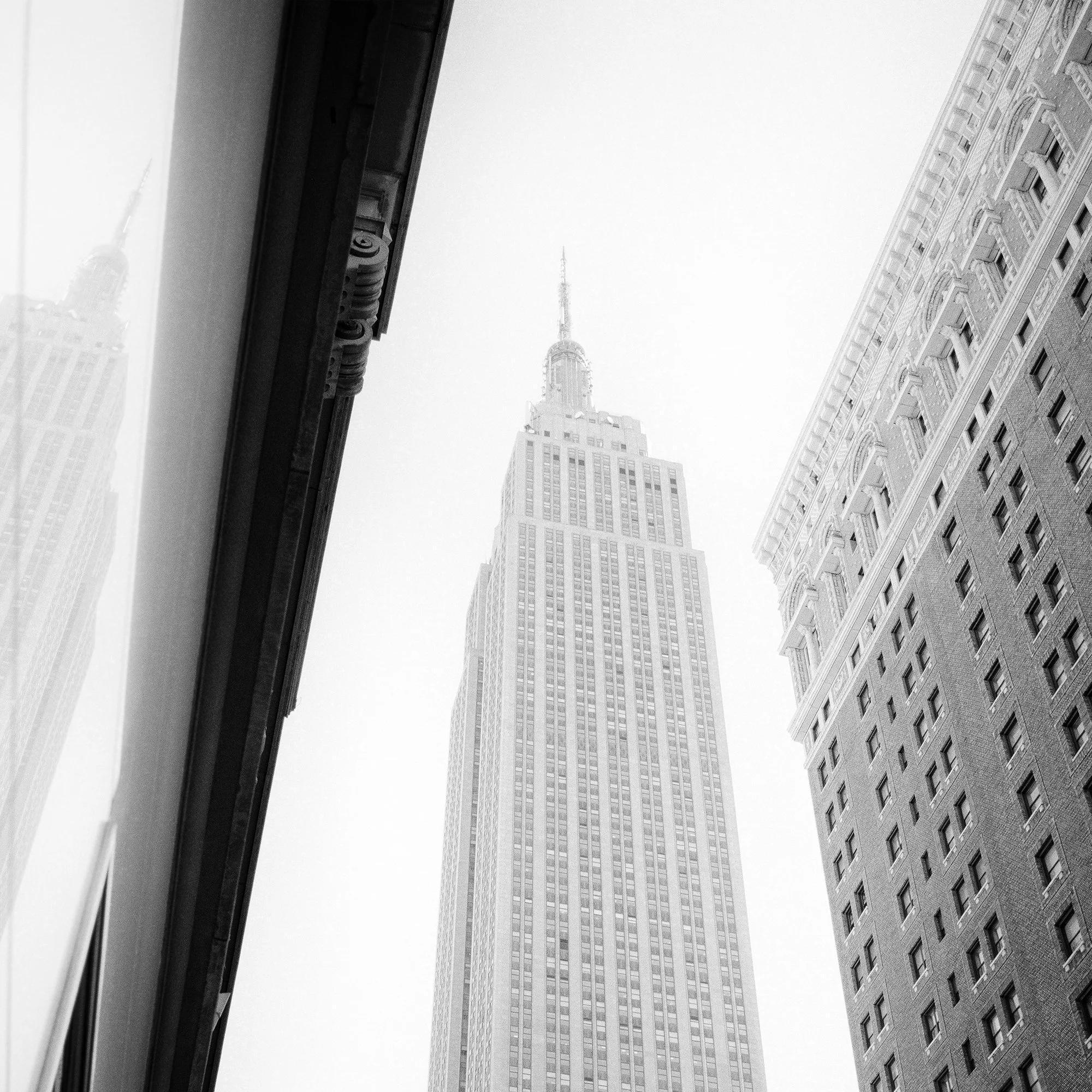 Detail of Empire State Building Study 1 by Gerald Berghammer showing the upper tower framed by Manhattan architecture.