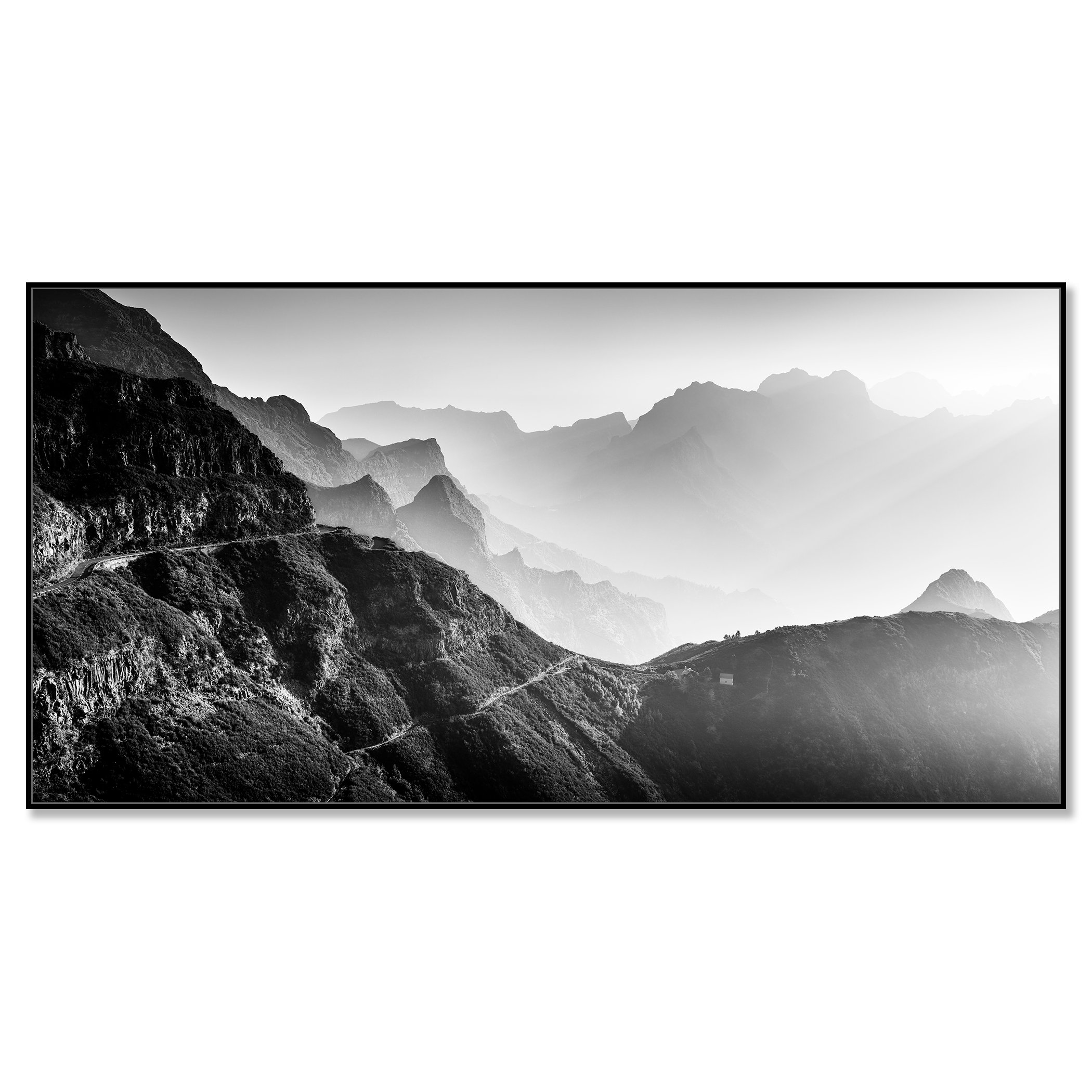 Black-and-white mountain landscape with layered peaks, a winding road and soft atmospheric haze – framed ArtBox black