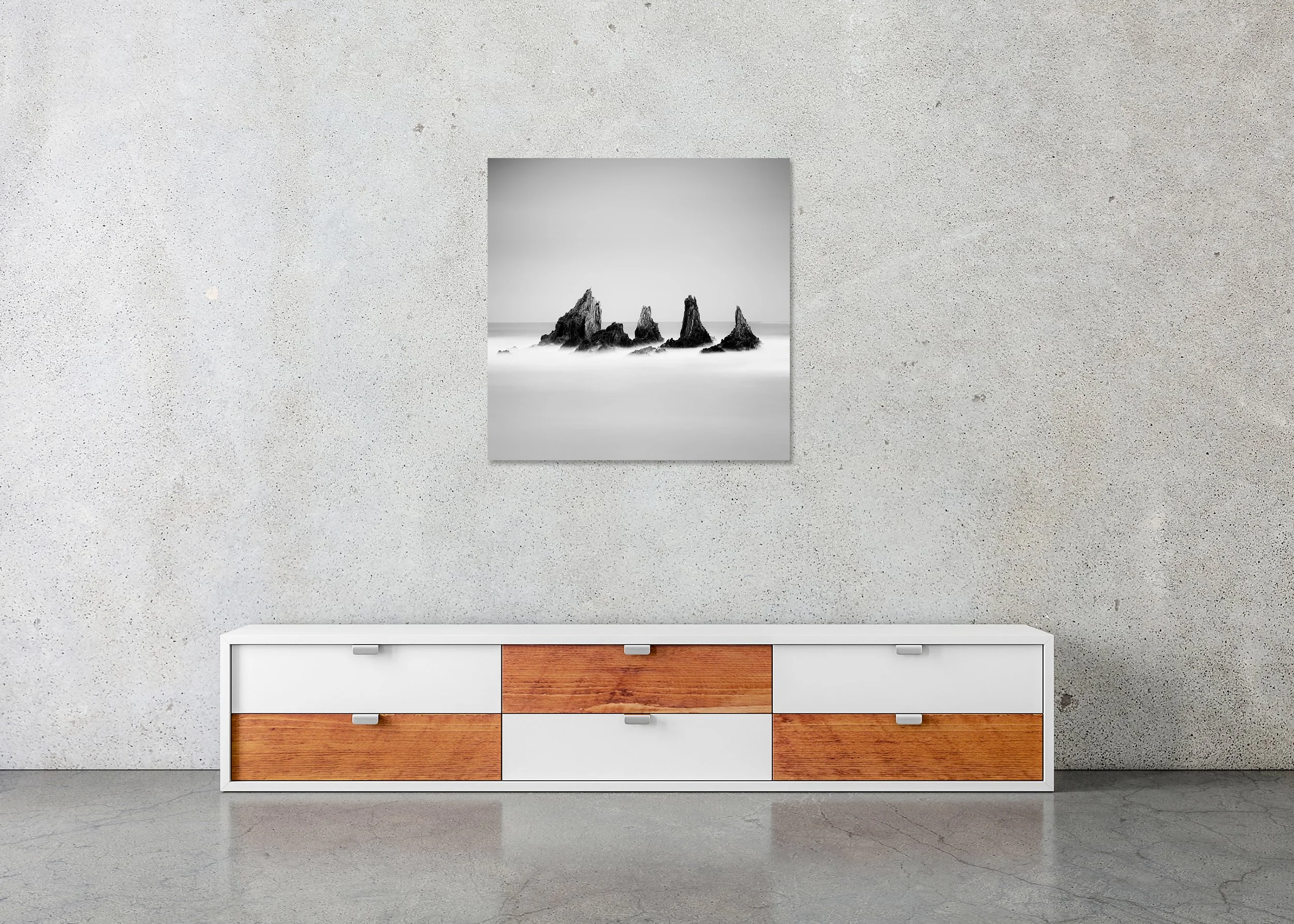 Frameless ChromaLuxe metal print featuring a black and white Atlantic seascape with five sharp sea stacks, tranquil water, and an open, cloudless sky.