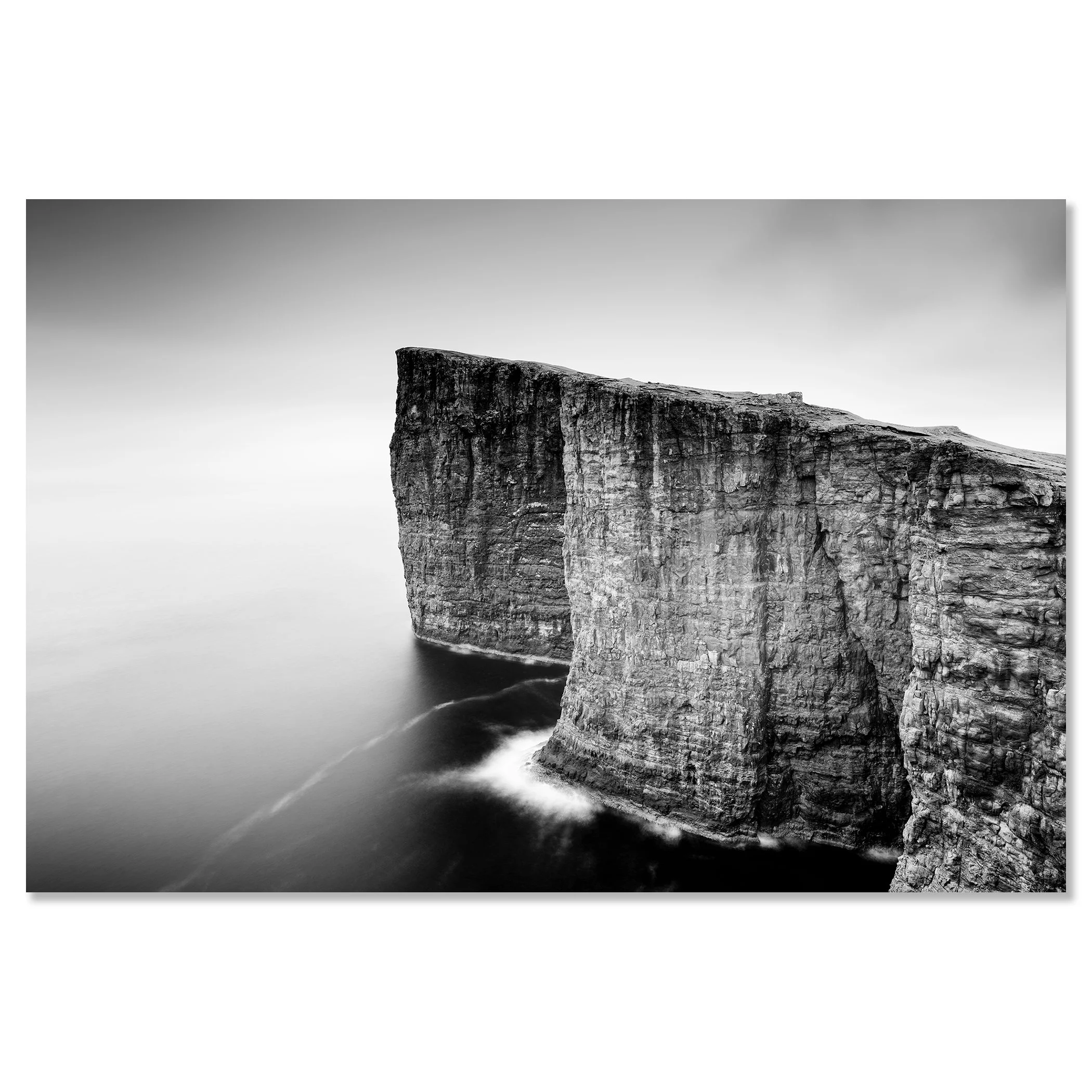 Gerald Berghammer - Black and white long exposure seascape photography. Tall, rugged cliffs by the ocean, waves crashing at the base, with a misty sky. Chromaluxe frameless