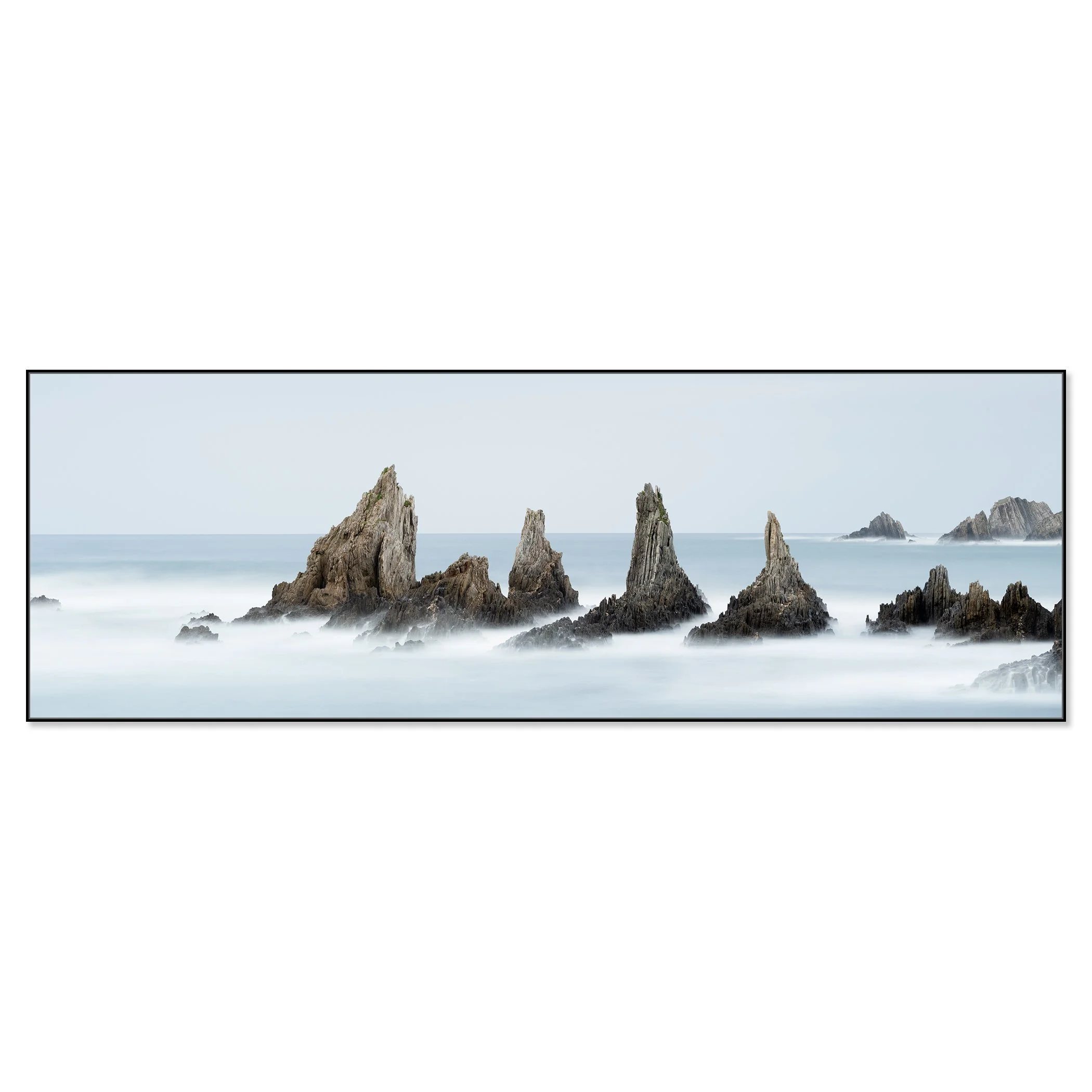 © 2023 Gerald Berghammer - Color seascape. Long exposure photograph of jagged sea stacks rising from the ocean with misty water and a light sky in the background. Chromaluxe framed black