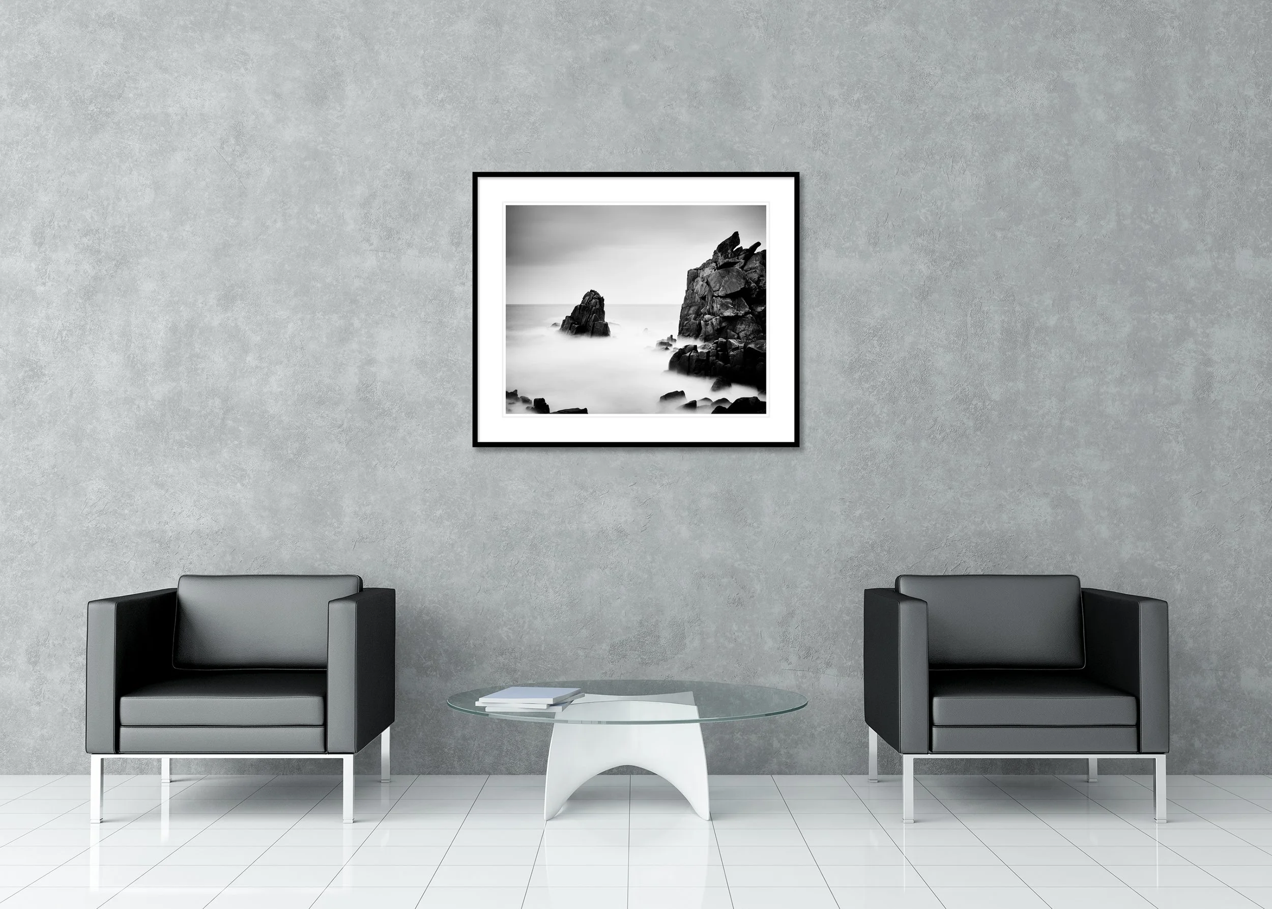 Black-and-white long-exposure seascape as an archival pigment print in a classic frame with a mount, showing rugged coastal rocks rising from a misty sea