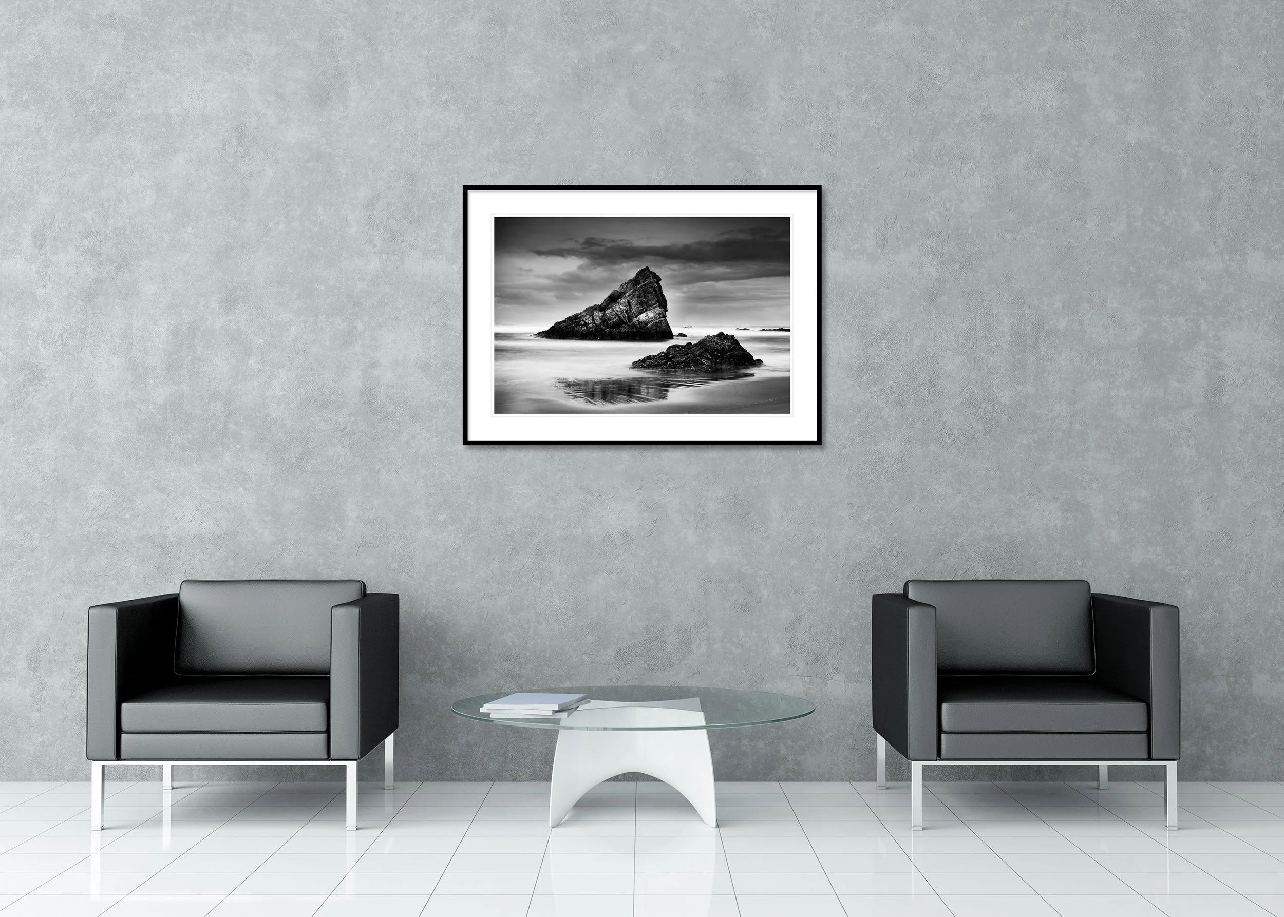 Black-and-white Bay of Biscay coastal print with jagged sea rocks, smooth water and dramatic clouds in a classic frame with mount