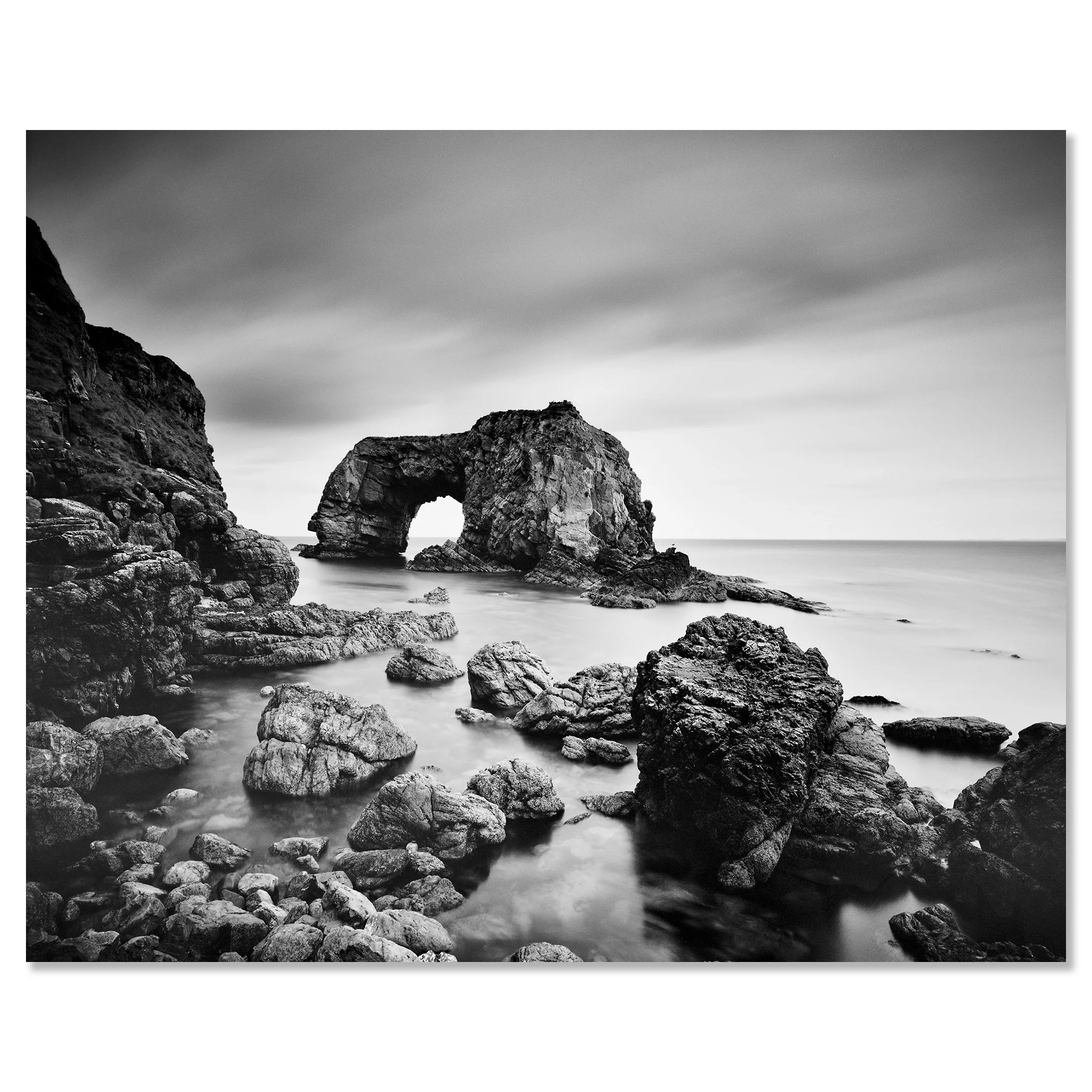 Black-and-white long exposure of Great Pollet Sea Arch surrounded by rocky shoreline and calm sea – dibond frameless