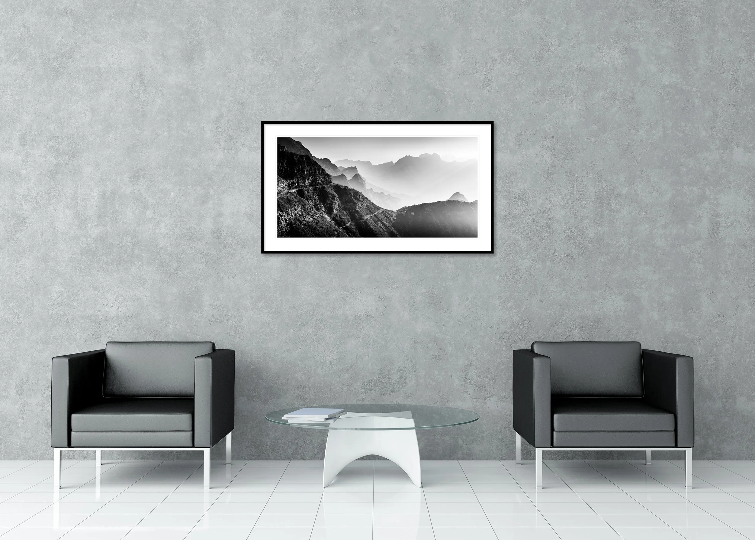 Archival pigment print in a classic frame with passe-partout, showing a black-and-white photograph of layered mountain ranges, foggy valleys and a narrow winding road.