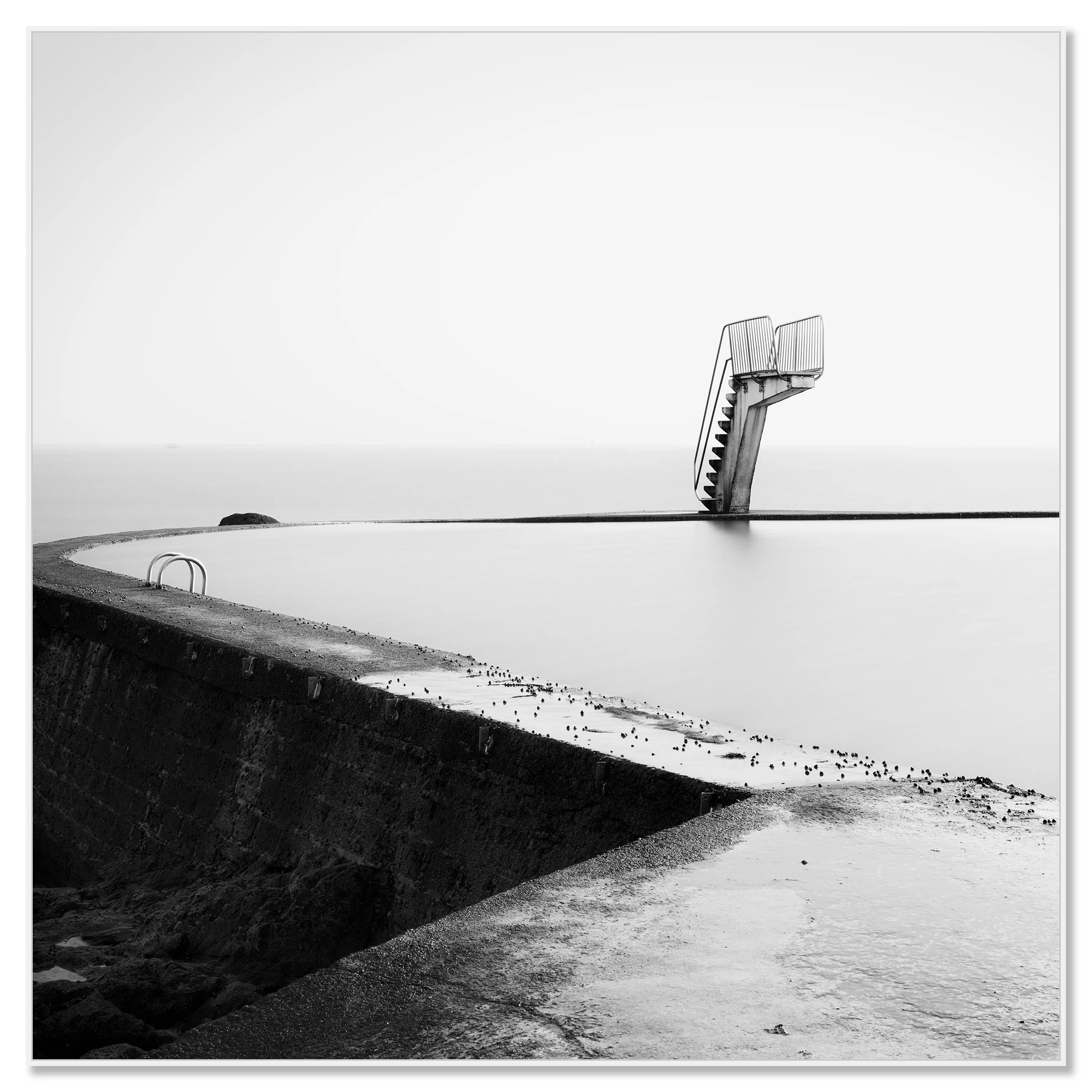Empty diving platform in a quiet seawater pool on the coast, captured in black and white – framed ArtBox white