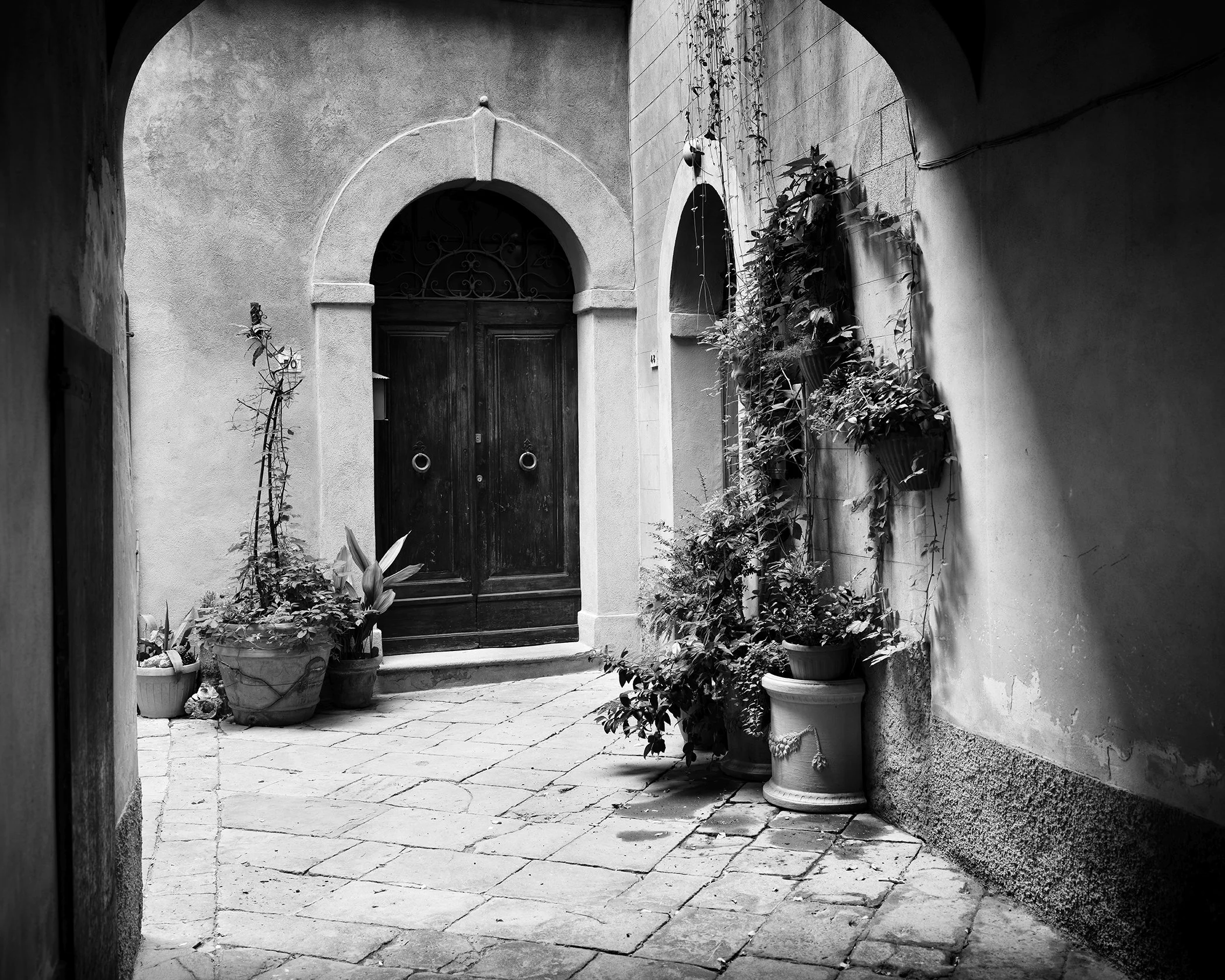 Tuscan Courtyard Study 2 by Gerald Berghammer, black-and-white fine art photograph of a historic courtyard in Tuscany, Italy.
