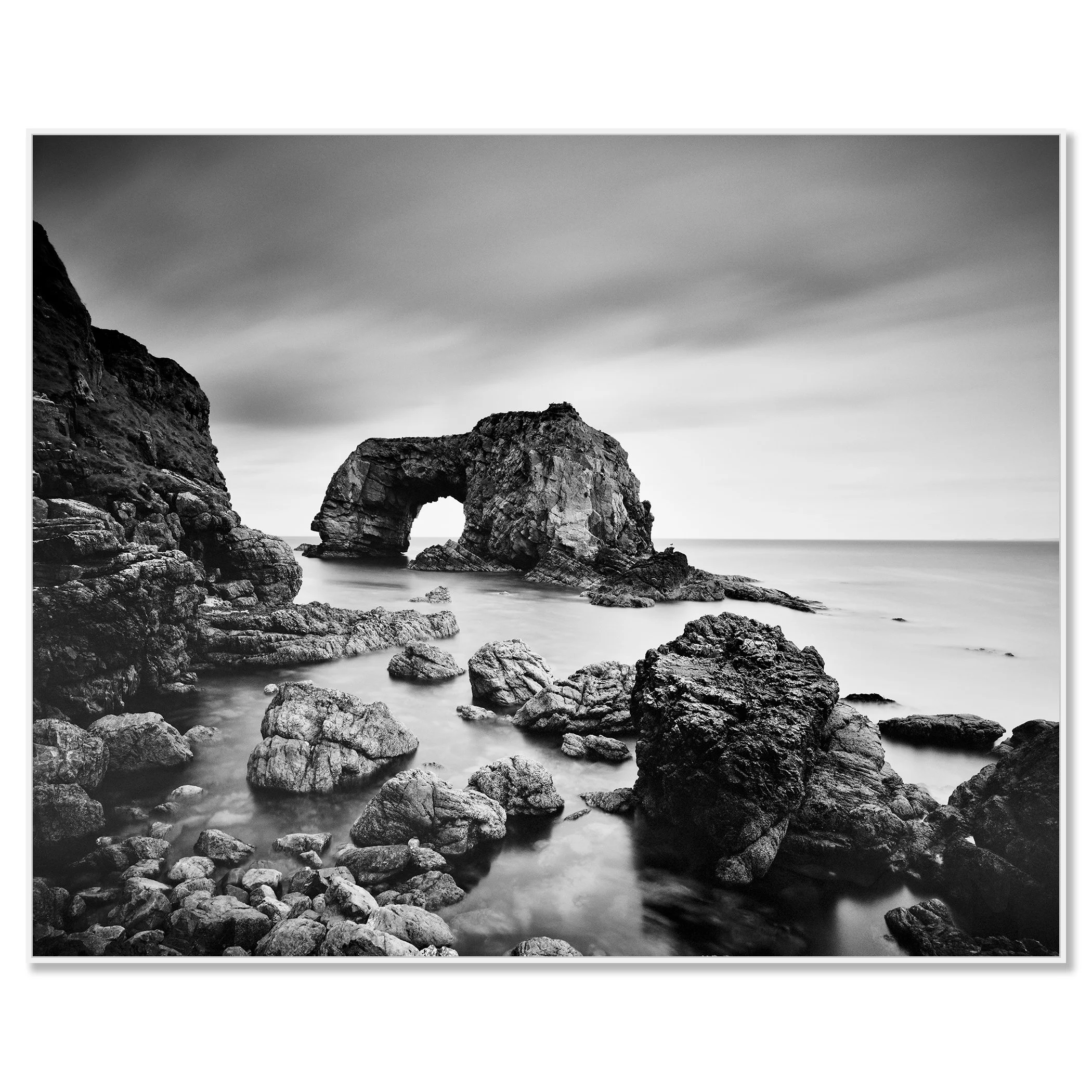 Black-and-white long exposure of Great Pollet Sea Arch surrounded by rocky shoreline and calm sea – framed ArtBox white