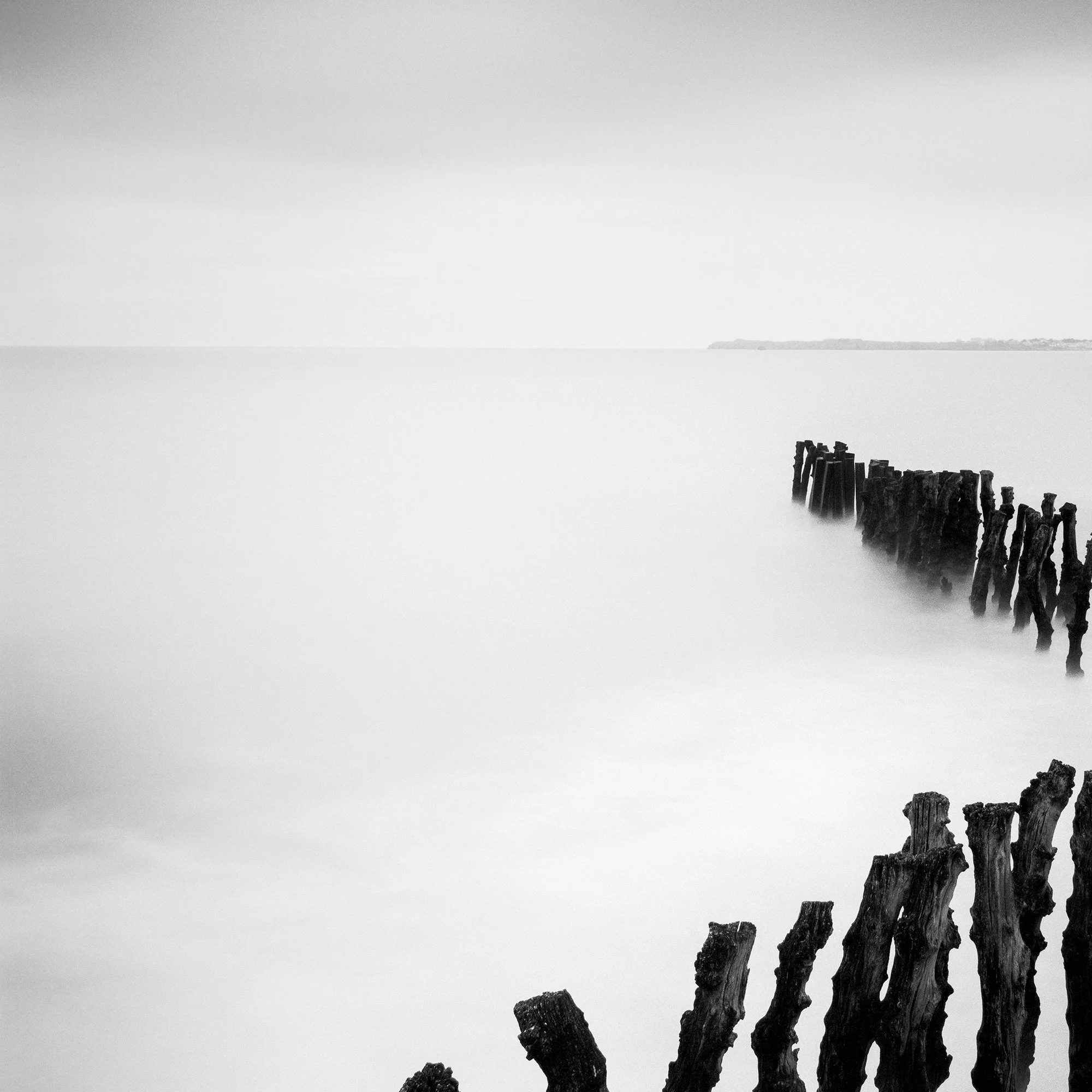 Detail of Sea Breakers showing weathered wooden groynes fading into mist-softened long-exposure water by Gerald Berghammer.
