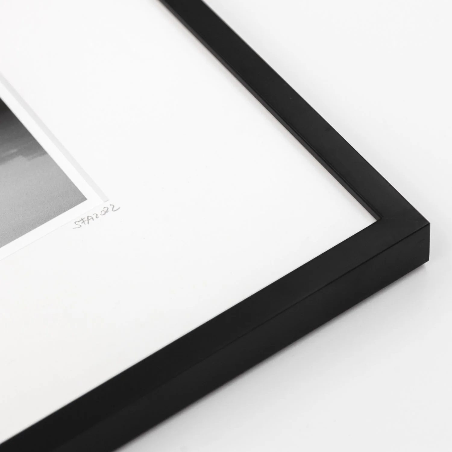 Close-up of the black wooden frame, archival white mount and handwritten edition details of Sea Stack Study 2 by Gerald Berghammer.