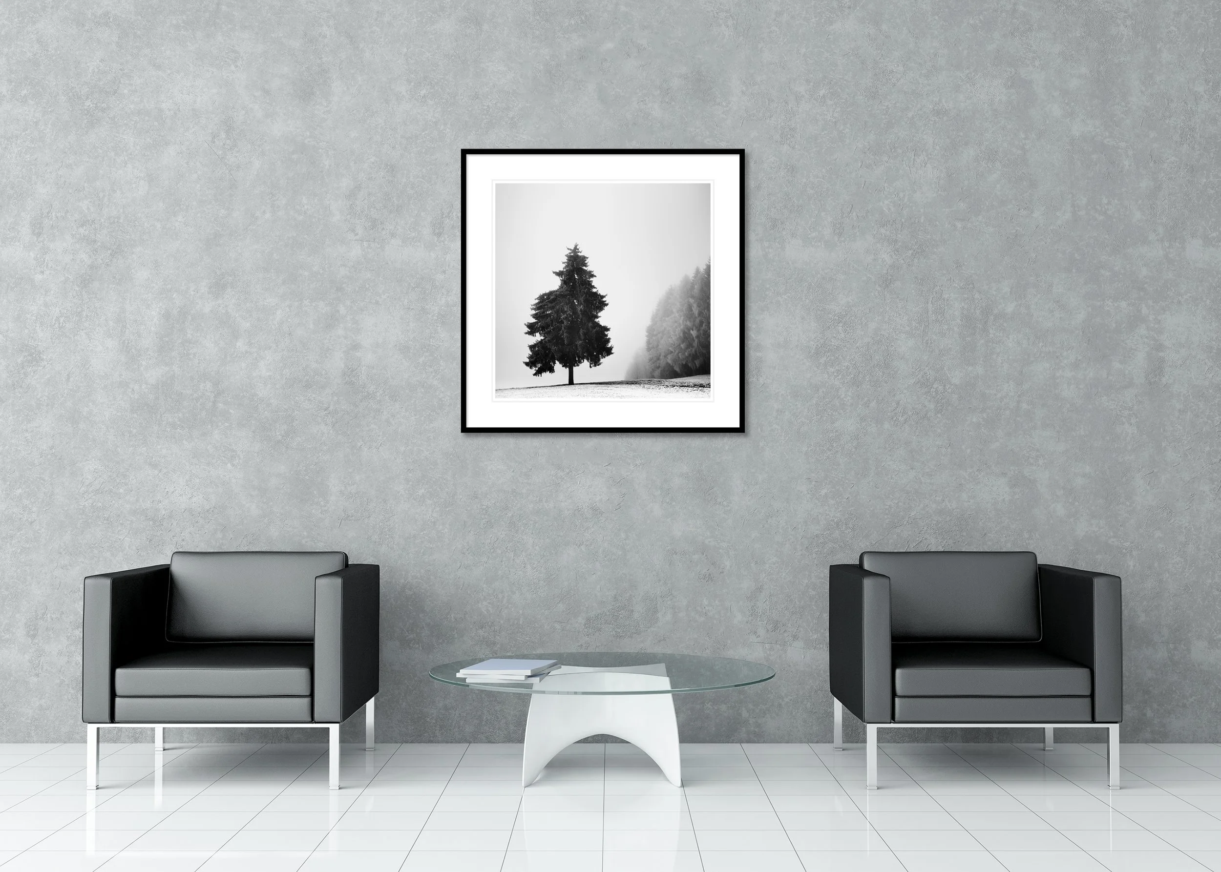 Solitary evergreen tree standing in a snowy winter field with foggy forest in the background, black and white minimalist landscape. Archival Pigment Print – Classic Frame with Passe-Partout