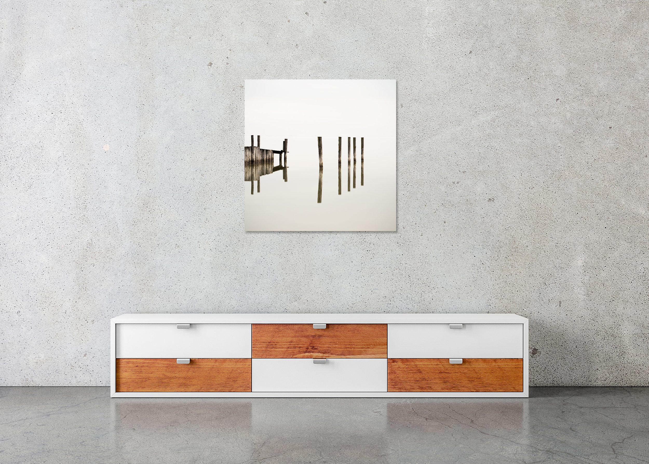 Wooden Pegs in the Lake – frameless colour photograph on aluminium Dibond displayed above a low cabinet.