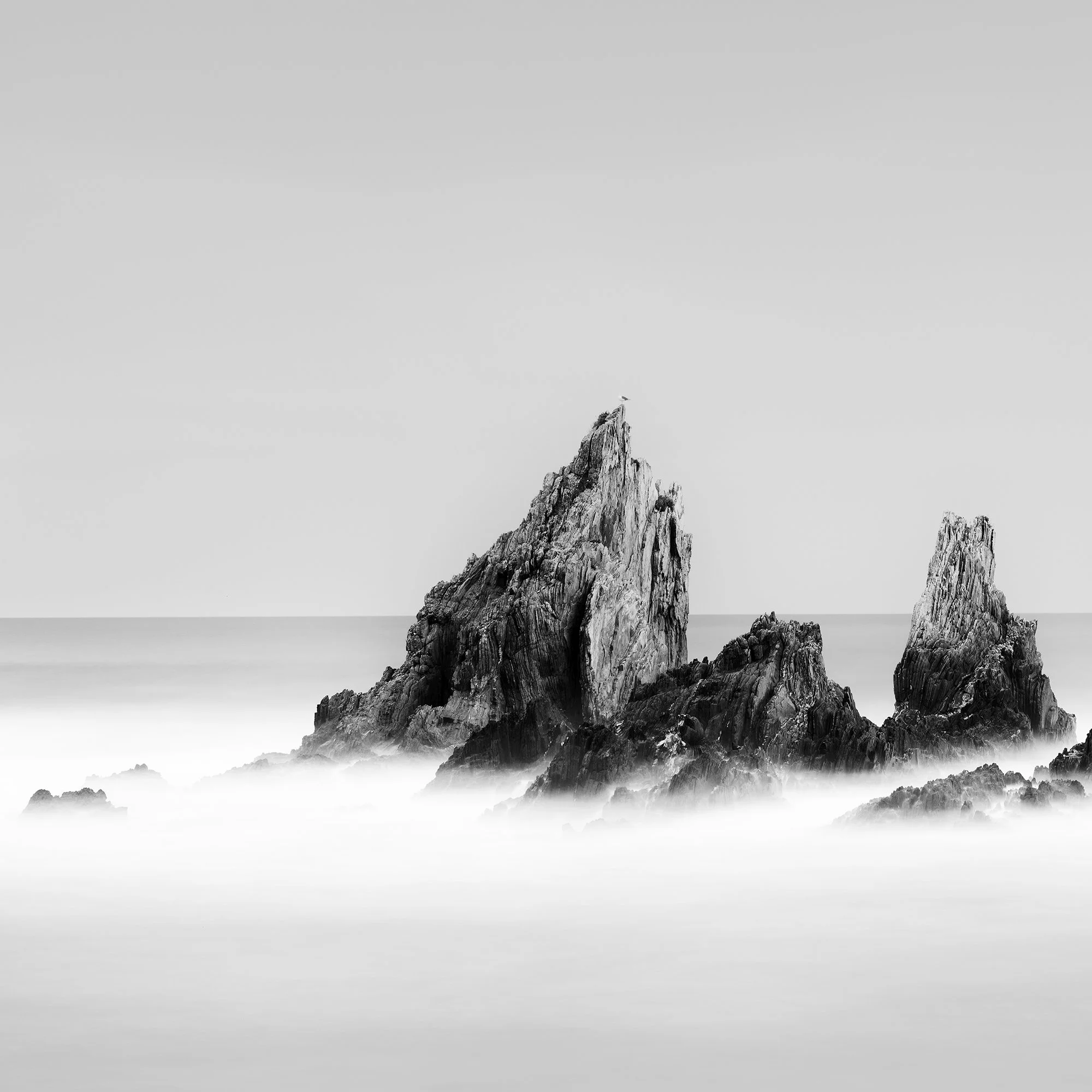 Detail of jagged rock formations rising through mist-like water in Rocky Peaks Panorama, Study 2, Spain, by Gerald Berghammer.