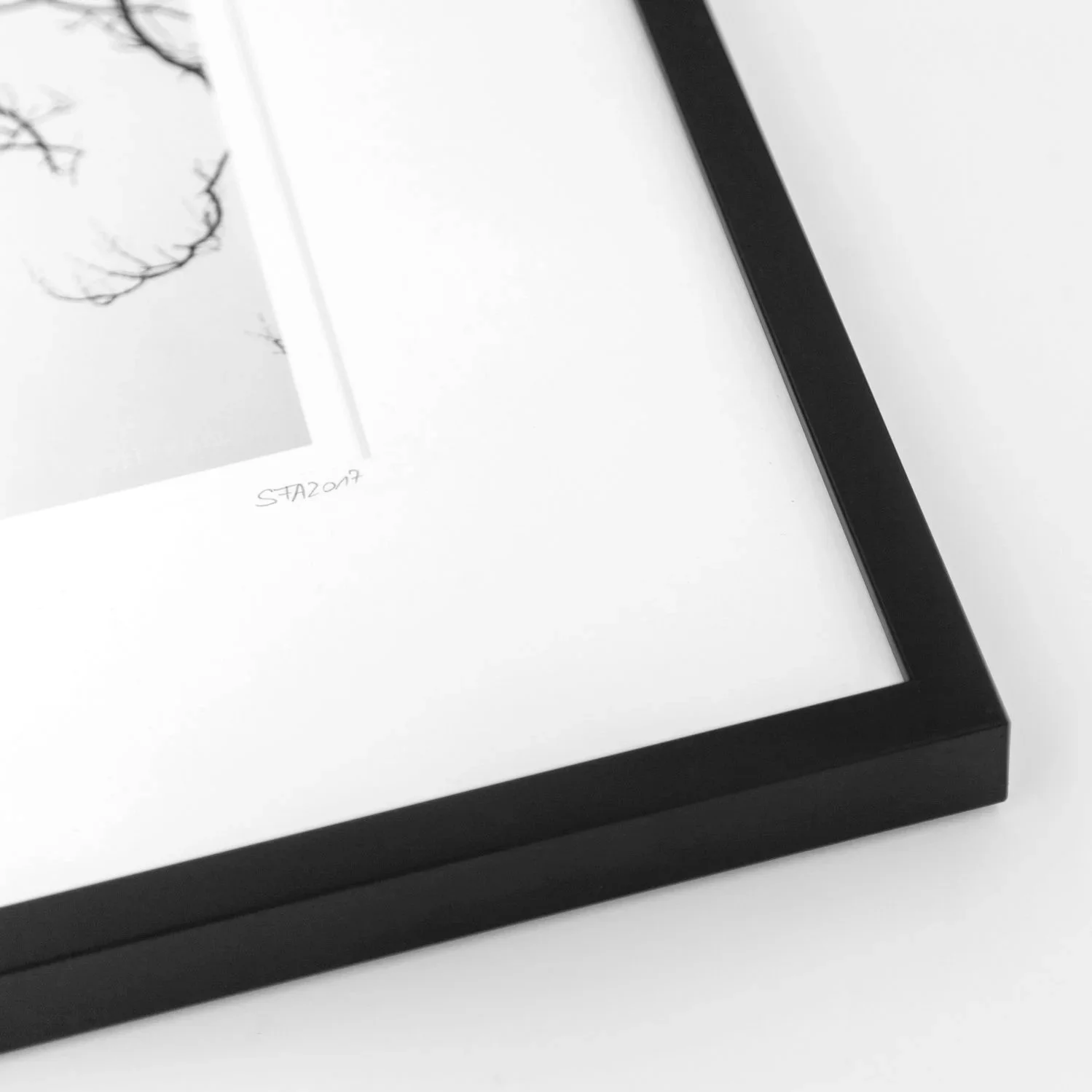 Detail of edition number 1/9 on Gerald Berghammer's Tree and the Tower print, with natural-white mount and black wooden frame.